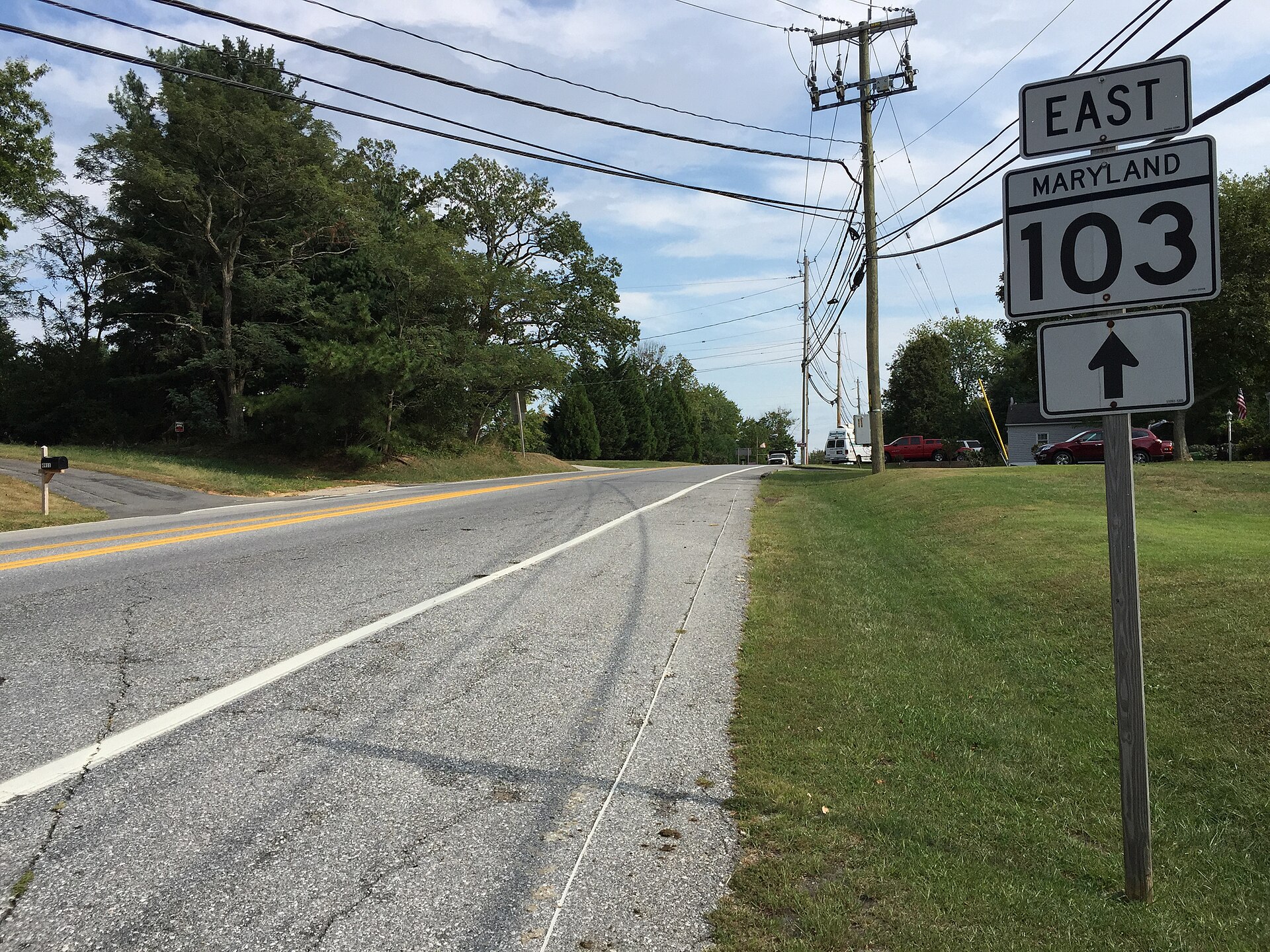 Green highway sign reading 'East Maryland 103' on a rural road in Ilchester, Maryland