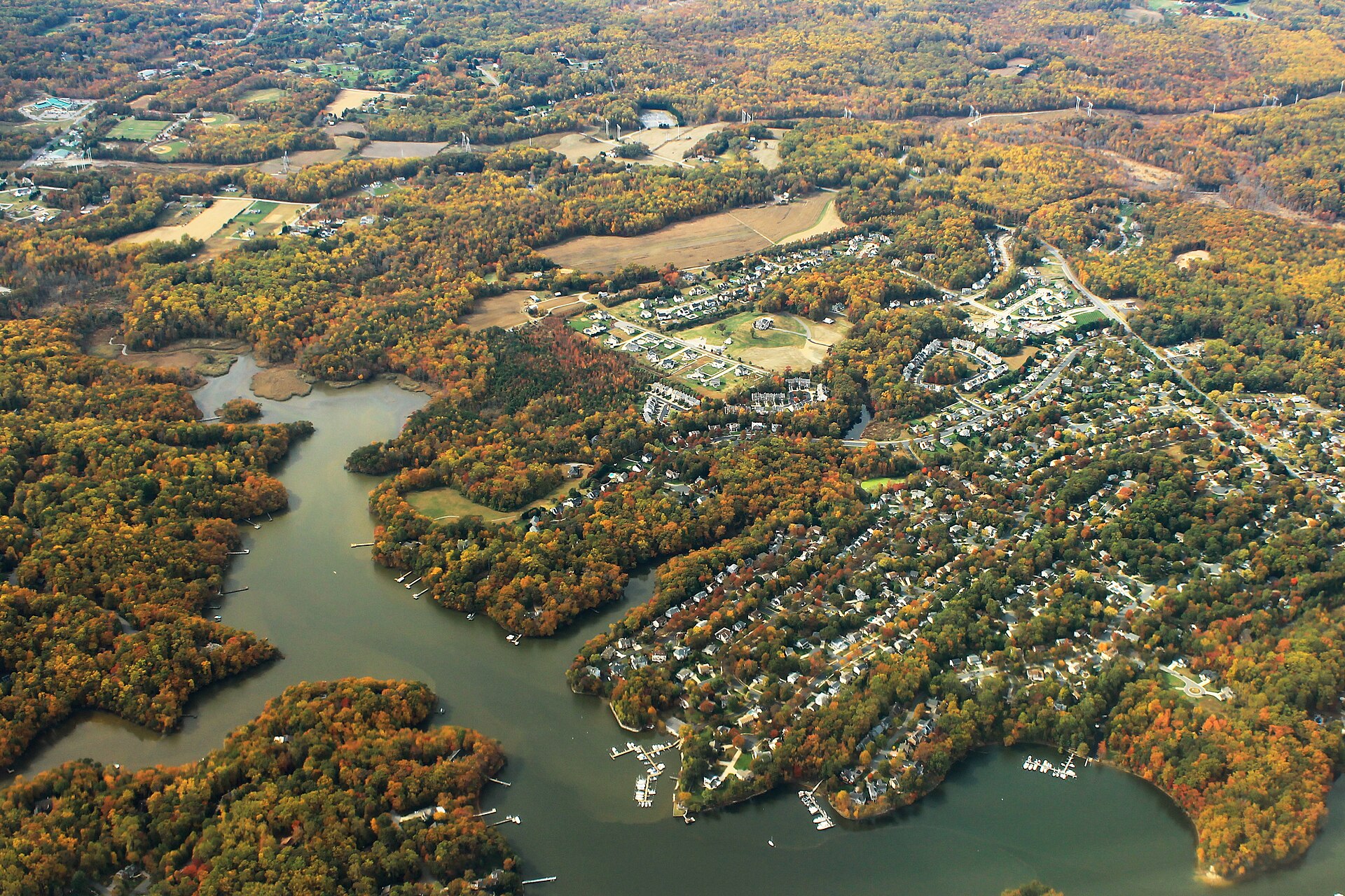 Aerial photograph of the South River winding through marina-lined neighborhoods in Riva, Maryland, with fall foliage