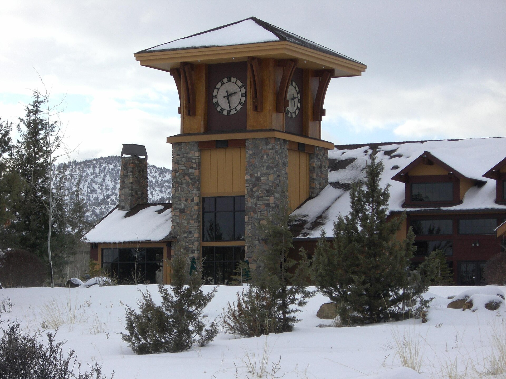 Stone and timber clock tower dusted with snow