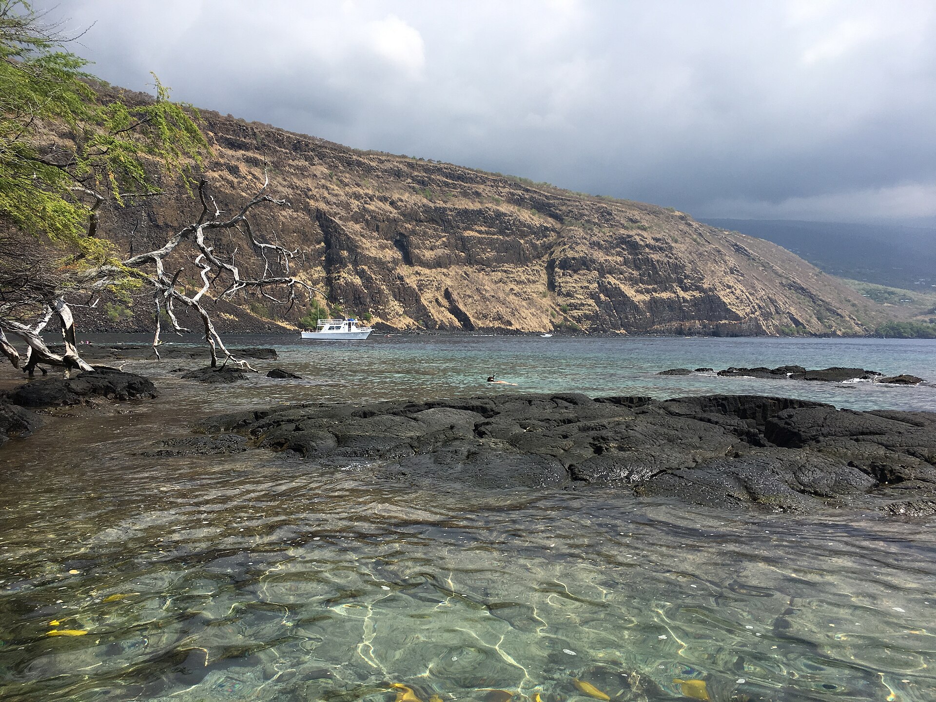 Kealakekua Bay with rocky cliffs and clear turquoise water.