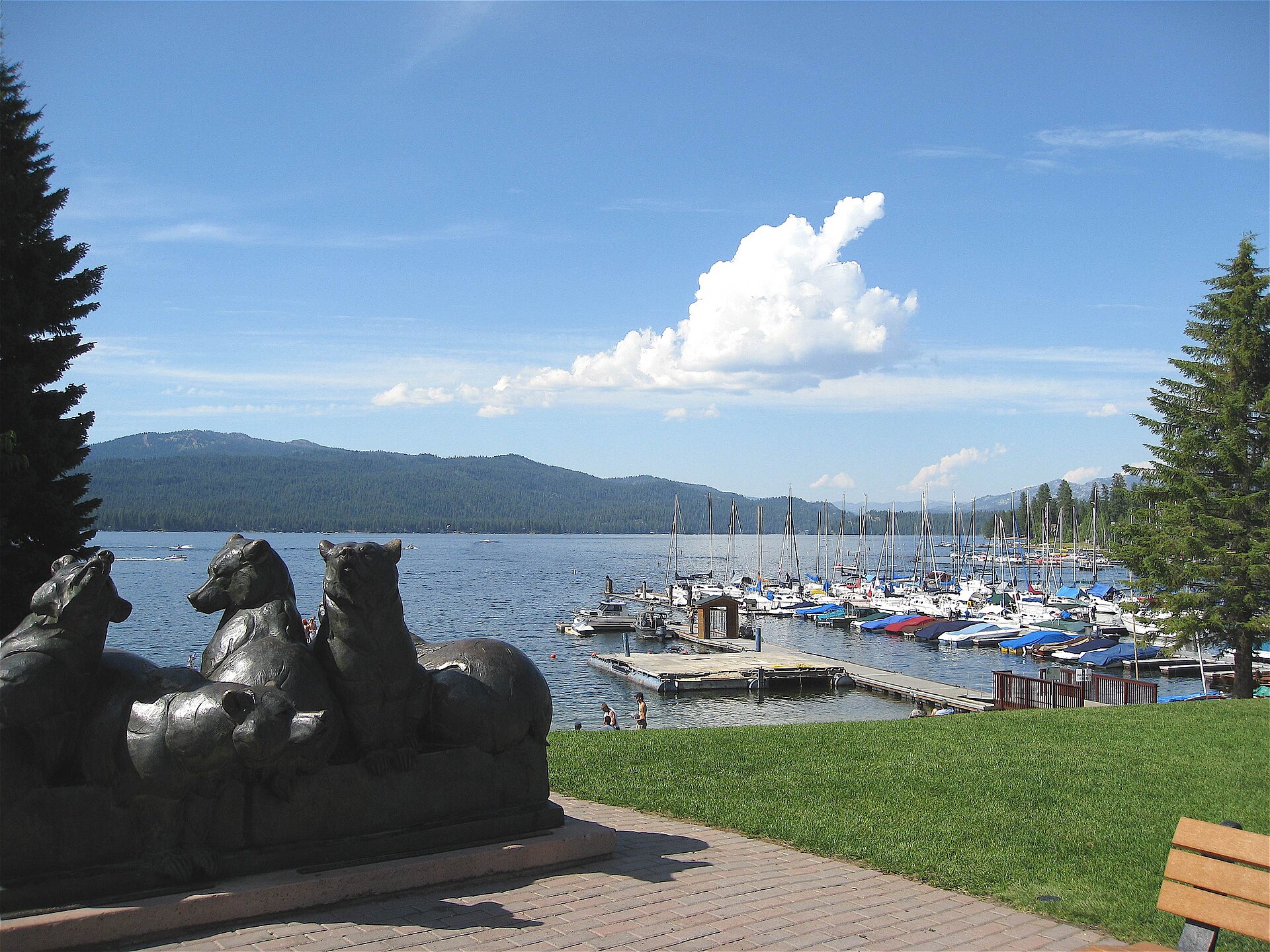Bronze bear statues on a brick patio overlooking Payette Lake and a marina in McCall, Idaho.
