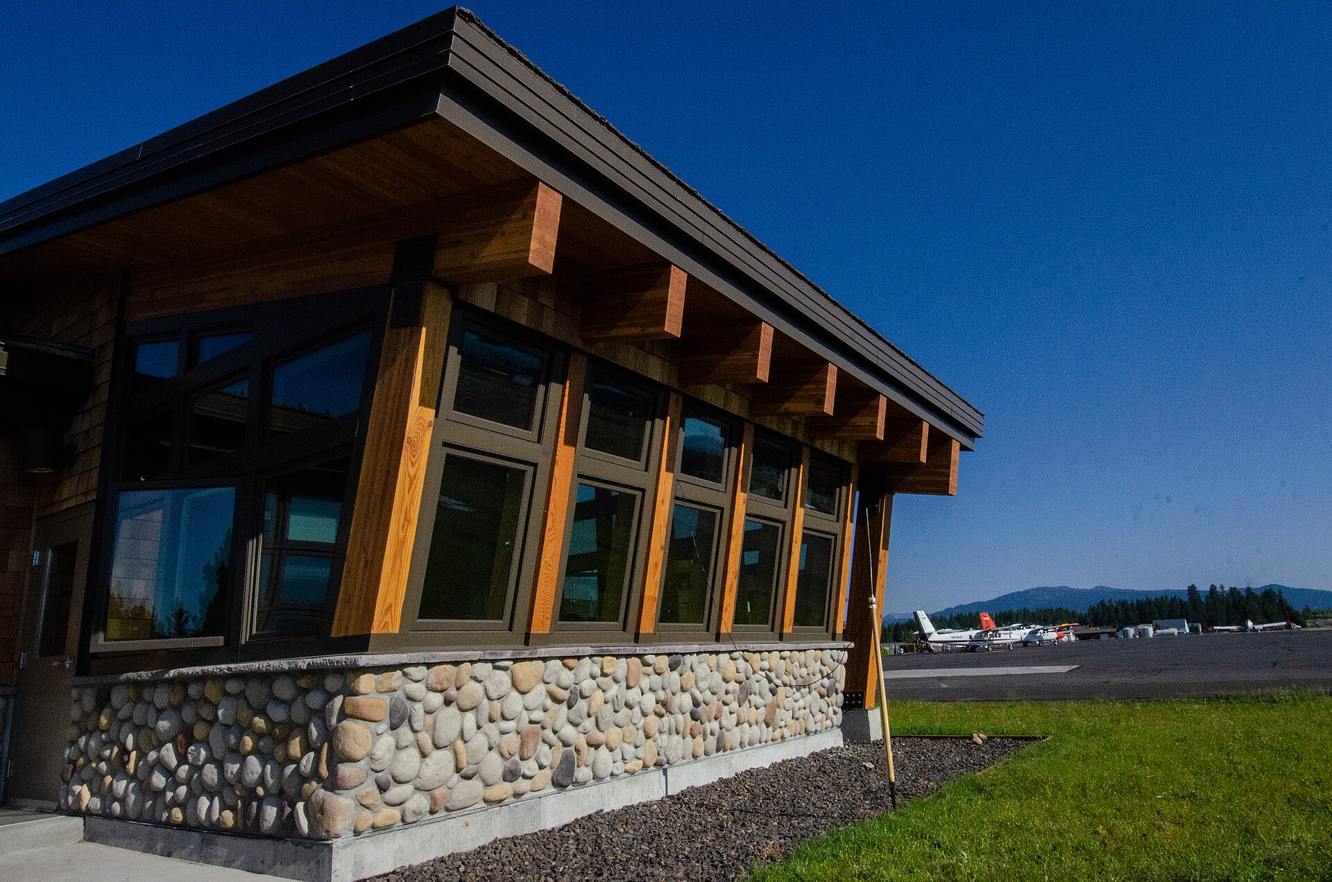 A modern wood-and-stone building with large windows at the McCall smokejumper base.