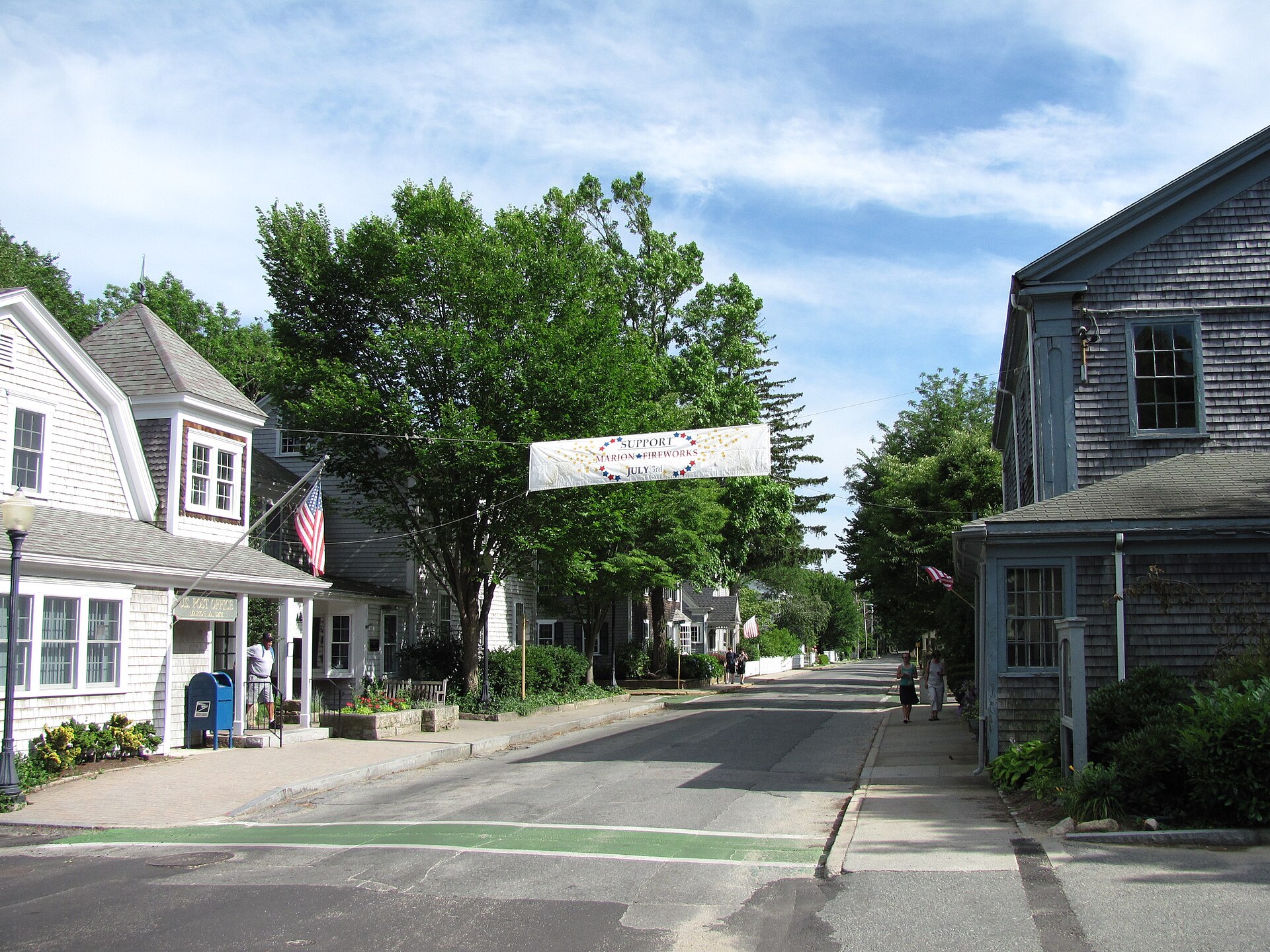 Front Street in Marion, Massachusetts, with historic shingled houses and a community banner strung across the road.