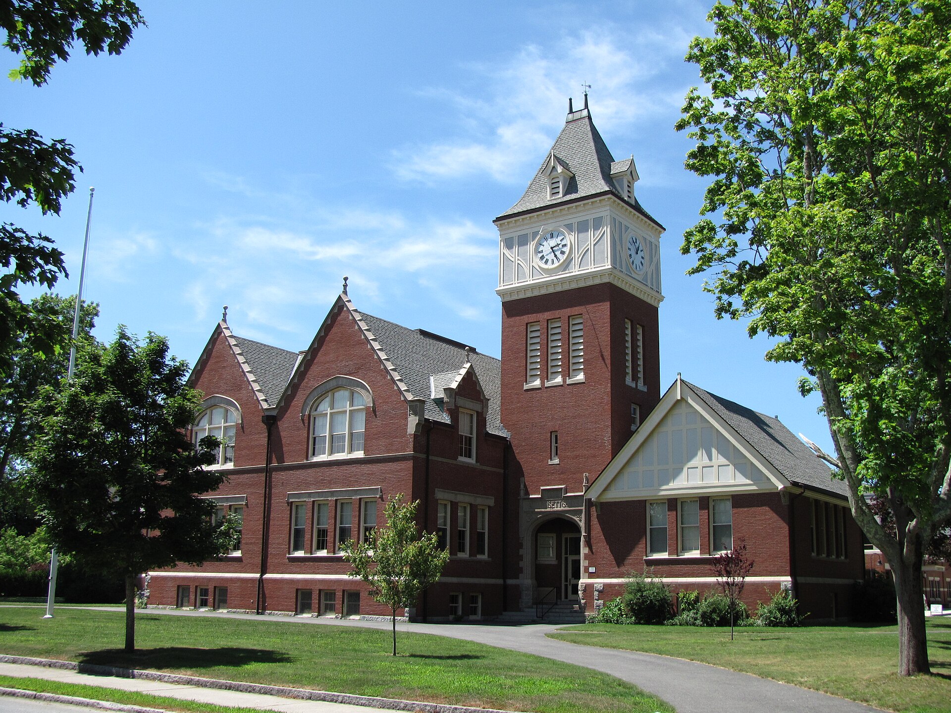 Brick Center School building with a tall clock tower under a blue sky