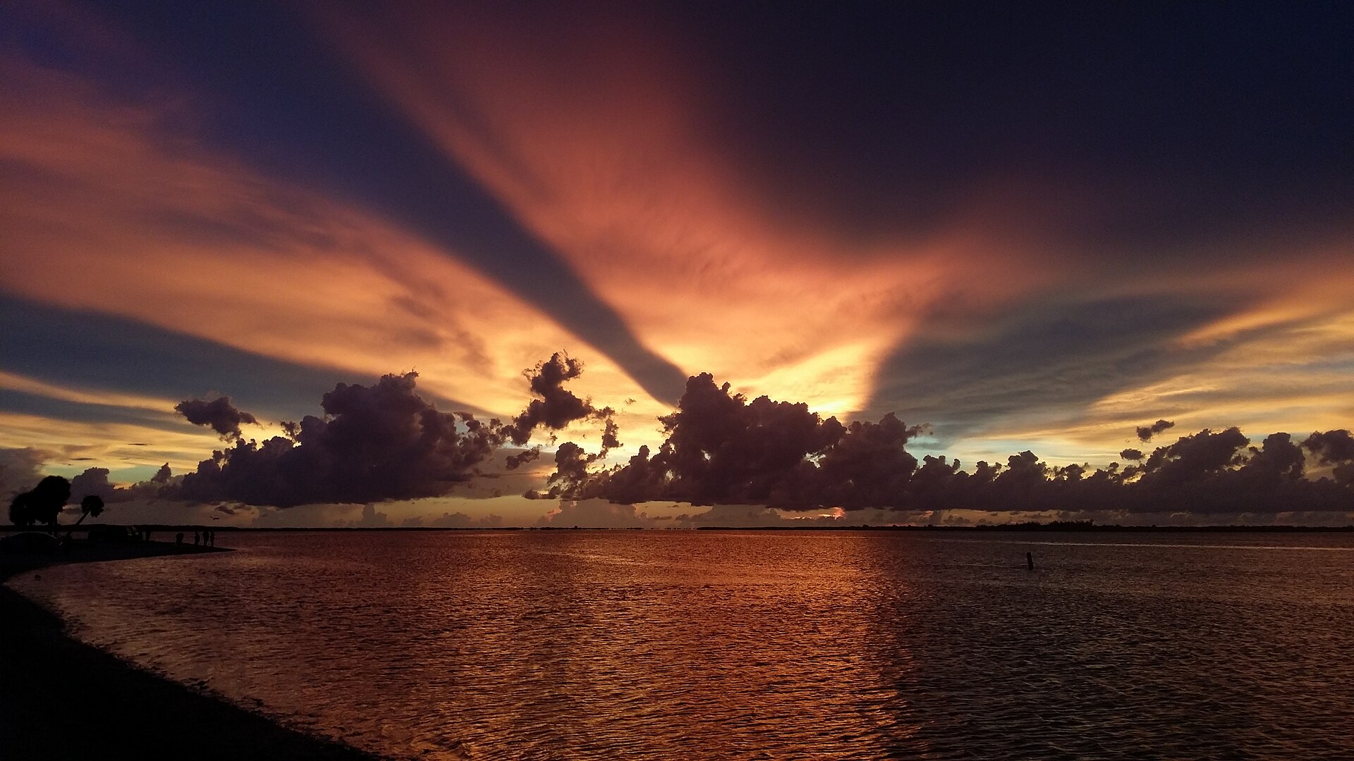 A vivid orange and purple sunset over calm water at Punta Rassa, Florida.