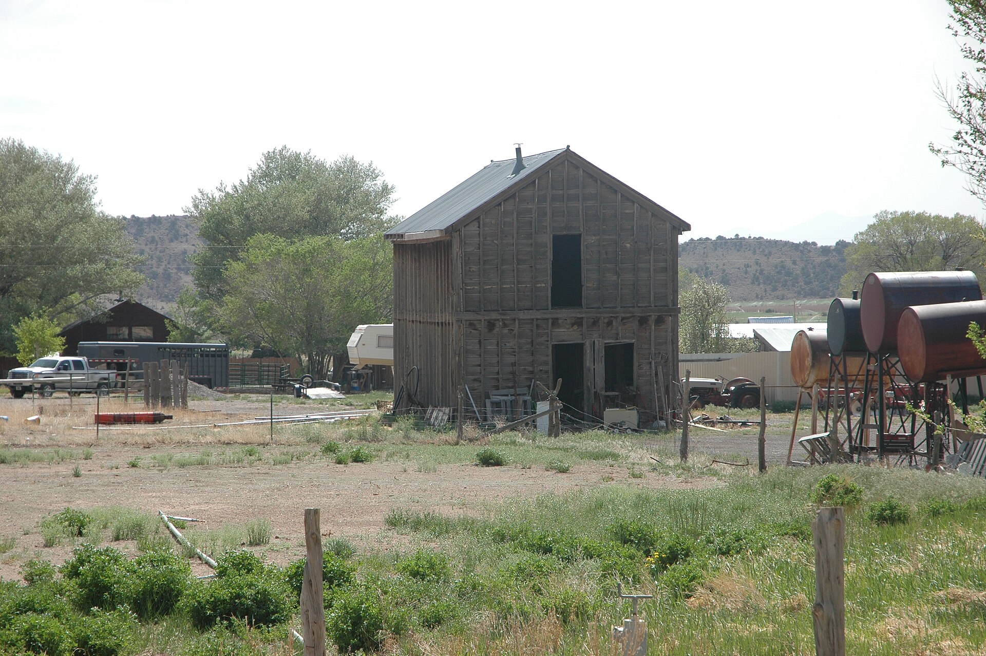 A weathered wooden granary building with a farmyard in Teasdale, Utah.
