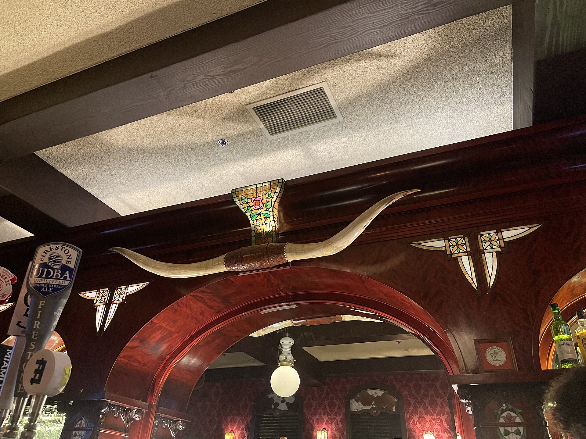 The ornate interior of the Far Western Tavern in Orcutt, with a longhorn-mounted archway and bar.