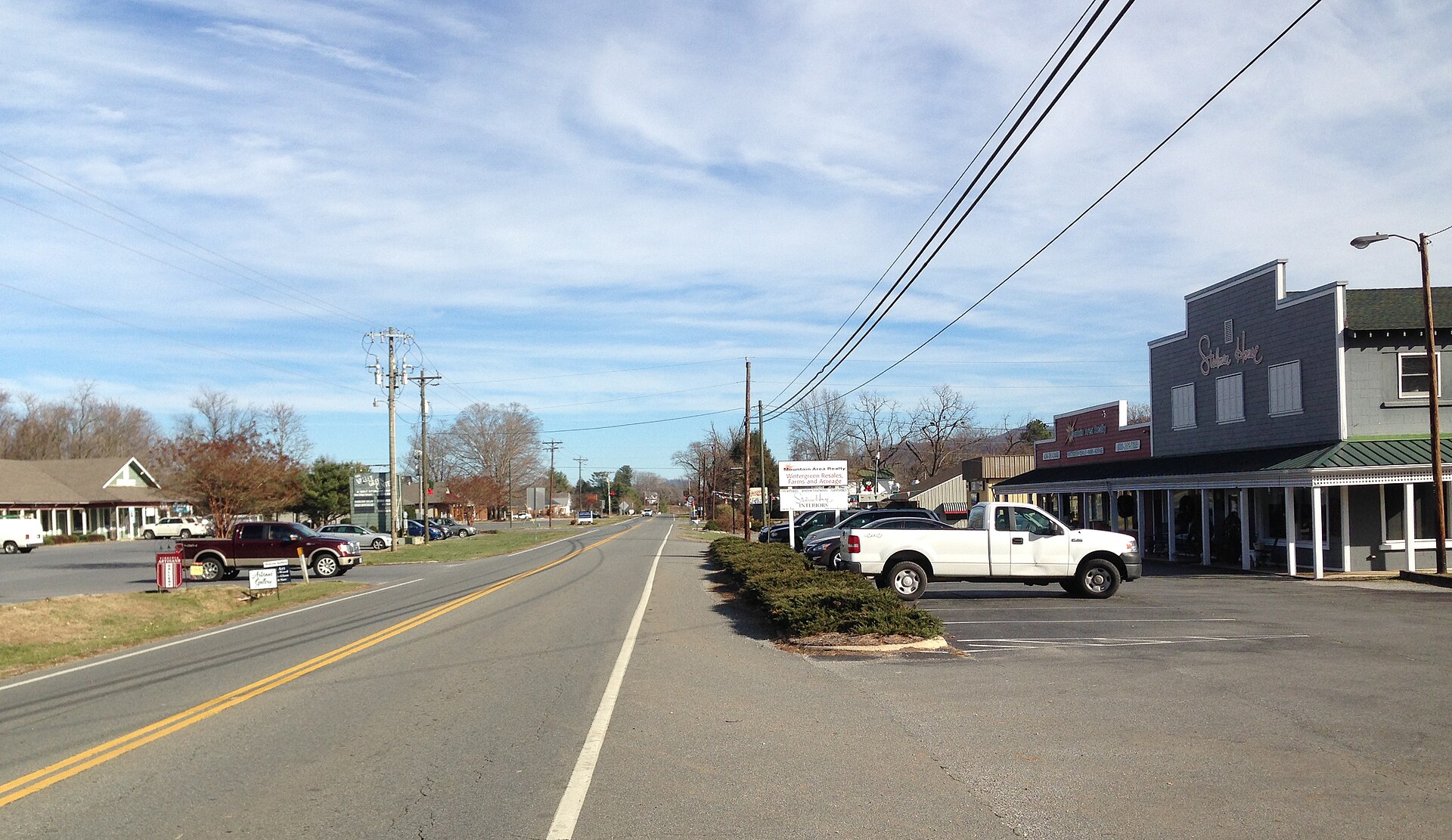 A mountain road lined with trees under a blue sky in Nellysford, Virginia.