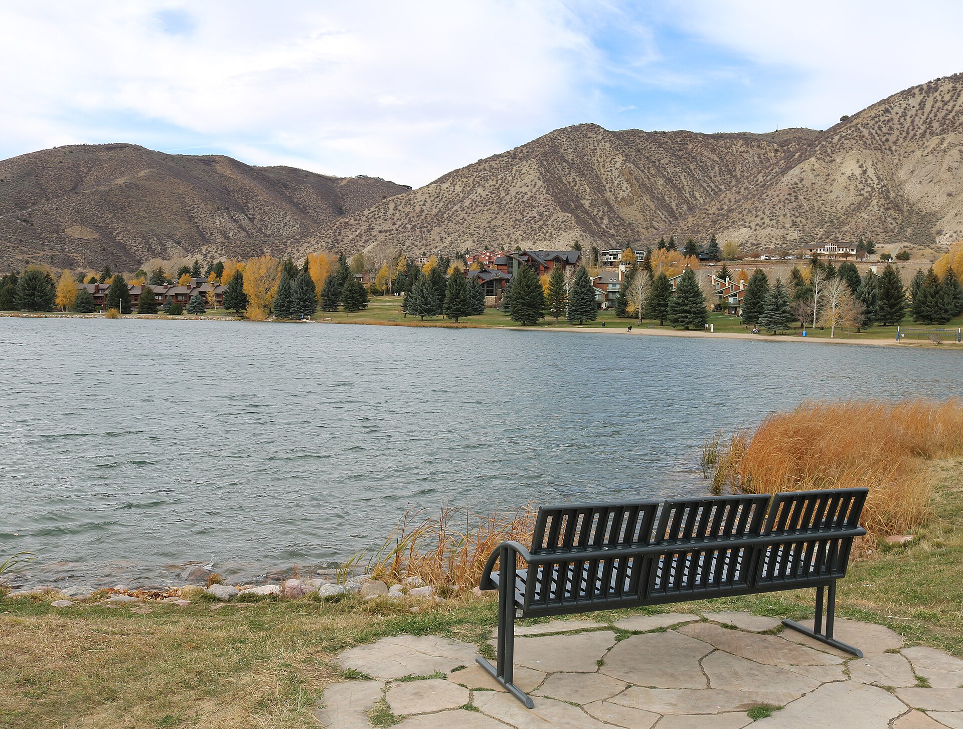 A park bench beside Nottingham Lake in Avon, Colorado, with fall colors