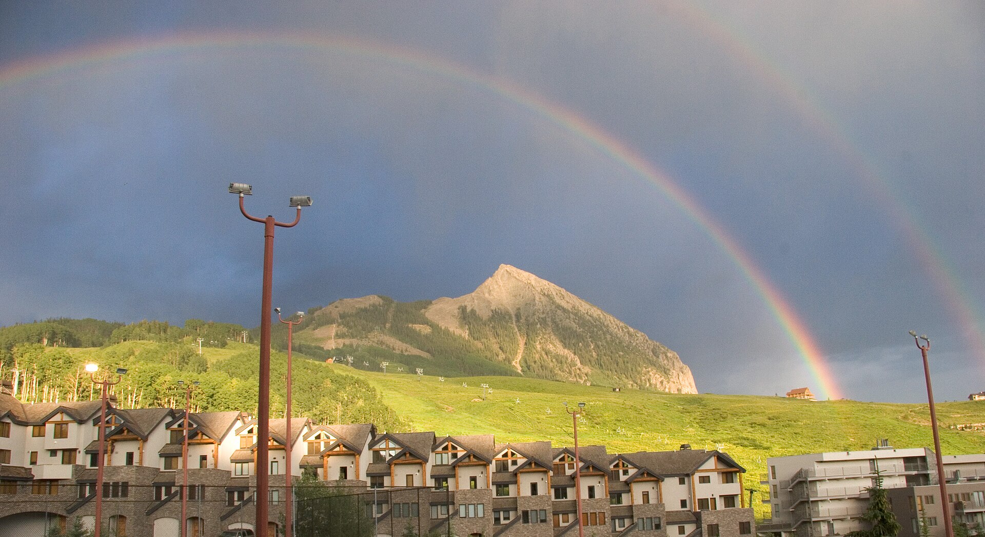 A double rainbow over Crested Butte Mountain Resort village and the mountain at Mount Crested Butte, Colorado