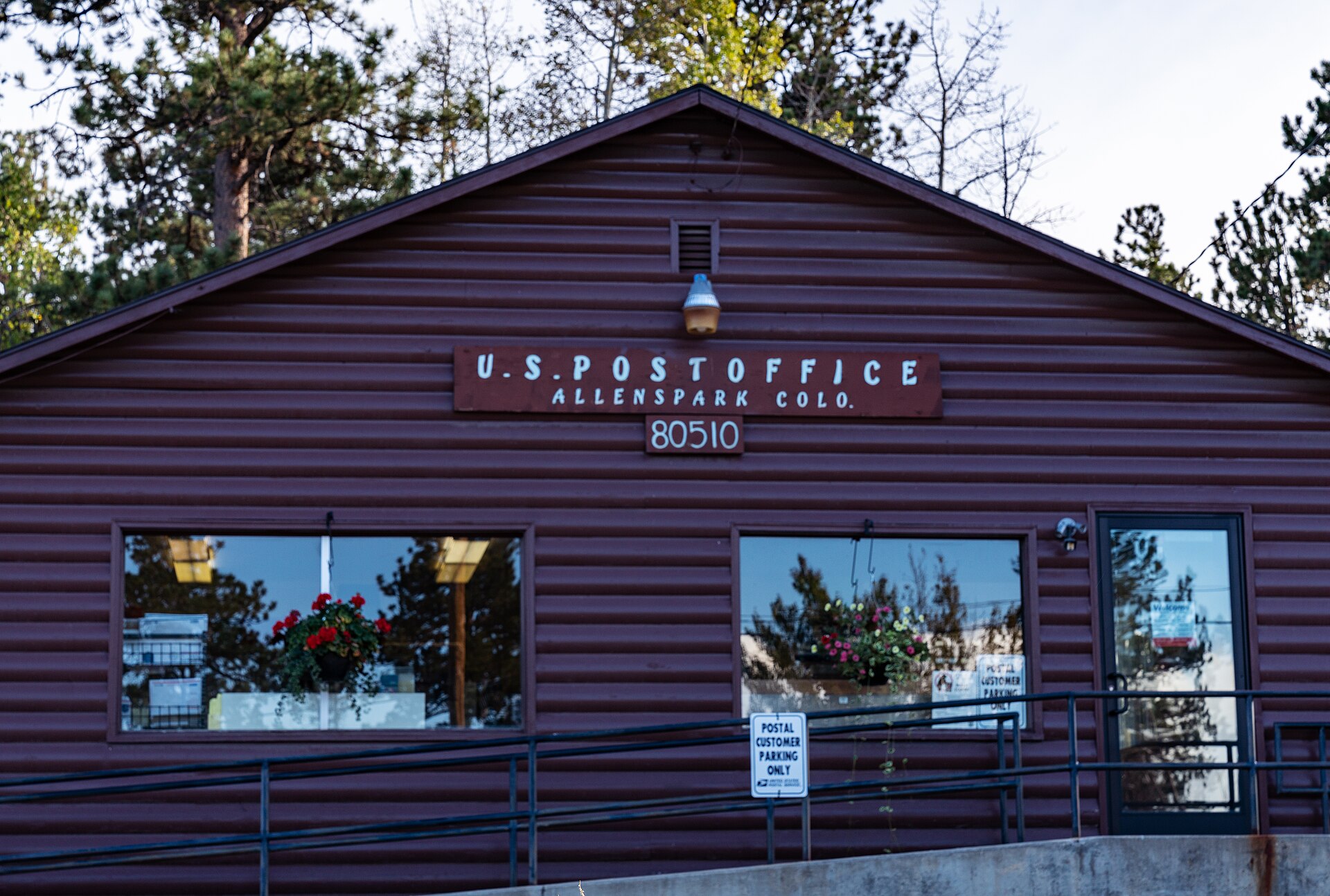 A small brown post office building with a sign reading U.S. Post Office, Allenspark, Colo.