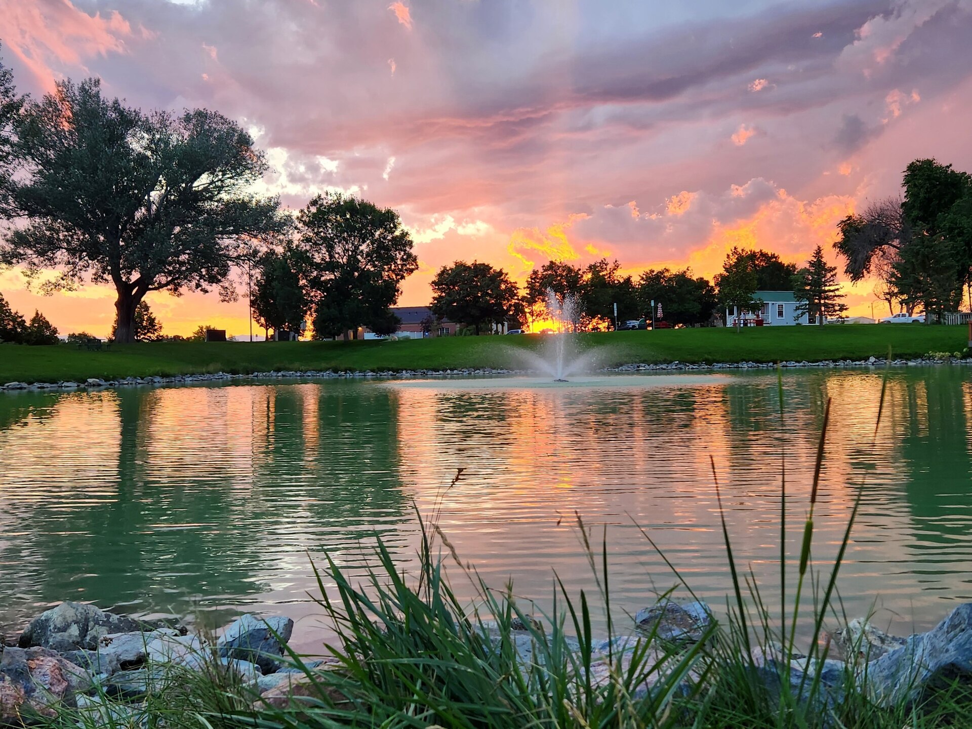 Colorful sunset reflected in Blue Spruce Pond in Severance, Colorado