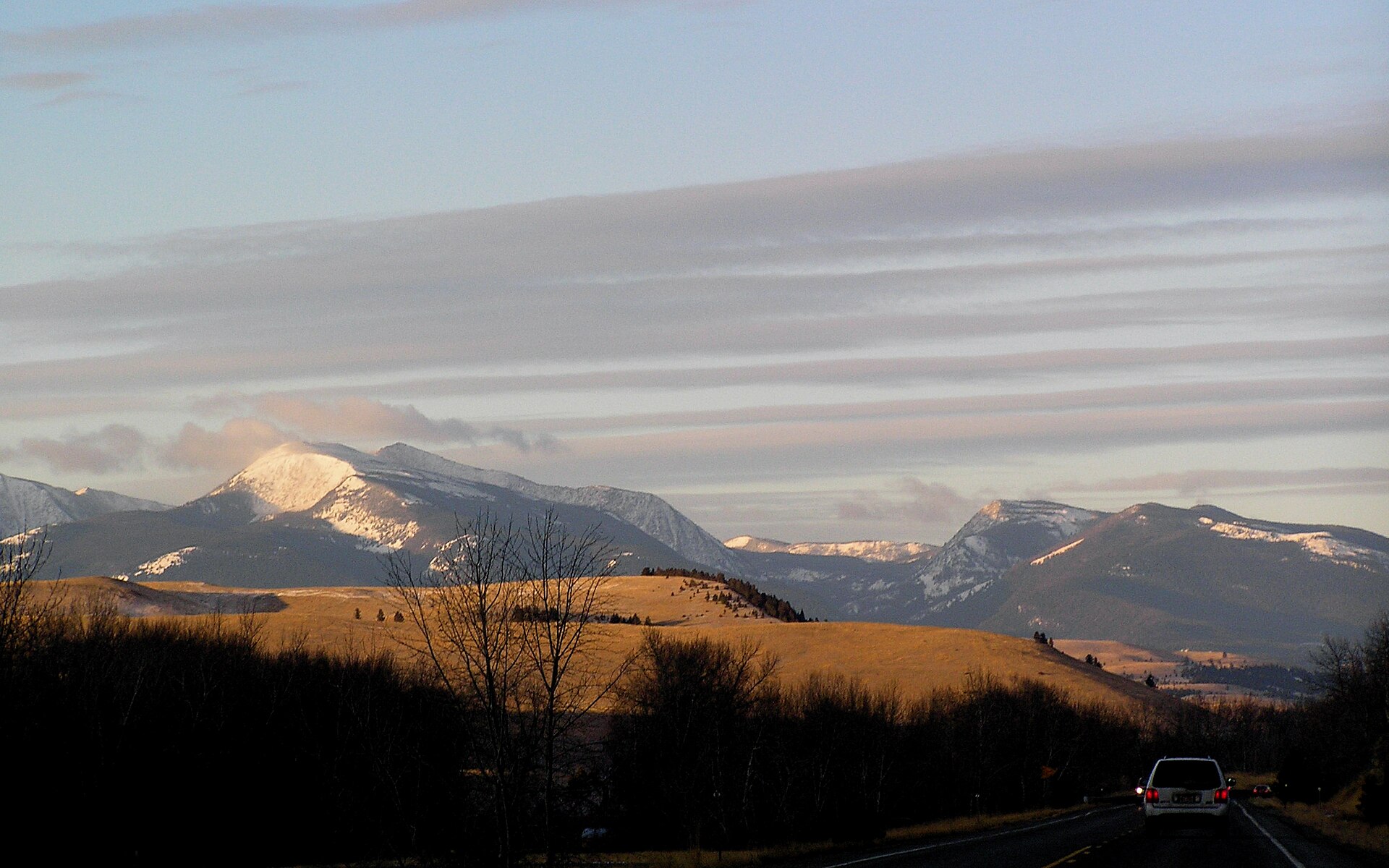 The Flint Creek Range at early morning, photographed from Highway 12 near Garrison, Montana, with golden light on the peaks.