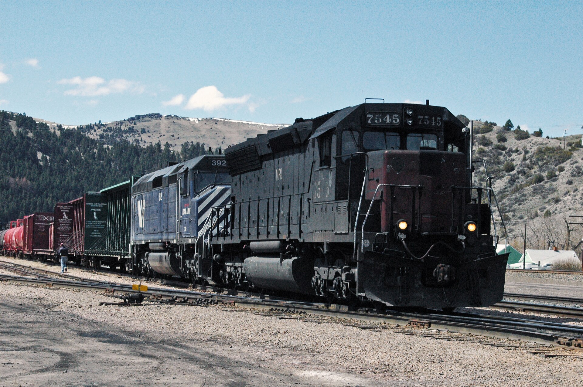 A black freight locomotive pulling freight cars on the tracks at Garrison, Montana.