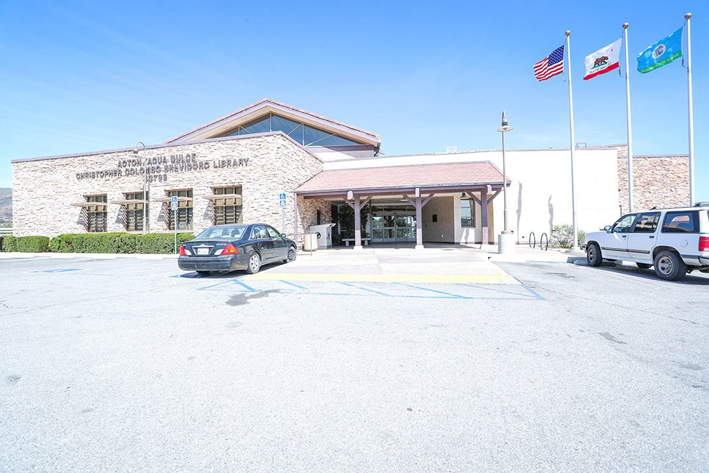 The Acton Agua Dulce library building with American and California flags