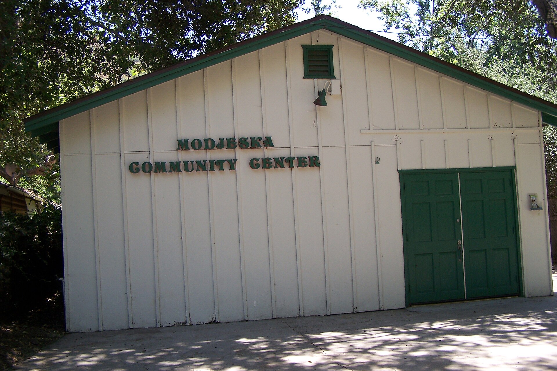 A white wooden community hall with green trim and a 'MODJESKA COMMUNITY CENTER' sign.