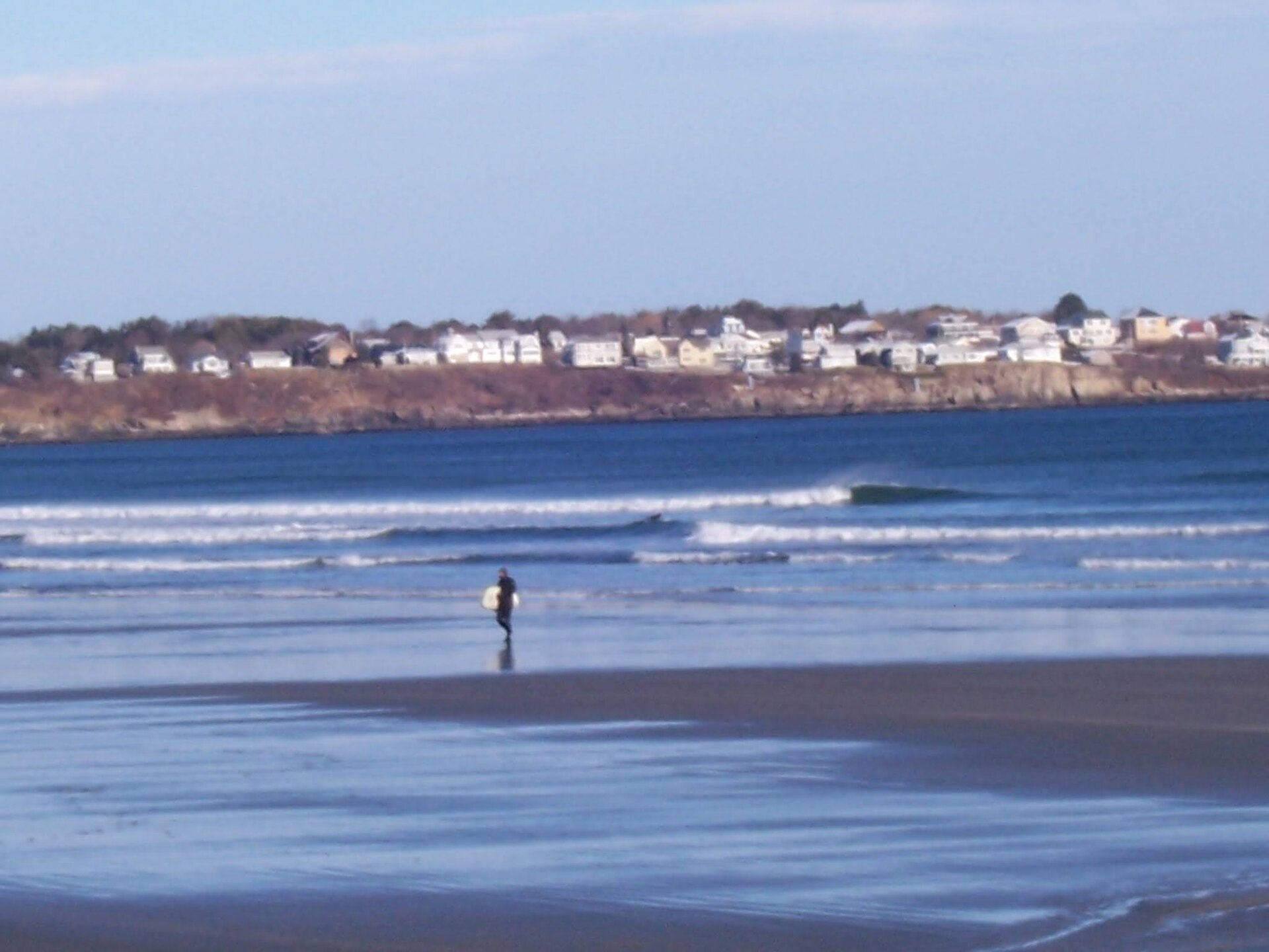A surfer in the waves at Long Sands Beach, Cape Neddick, Maine.