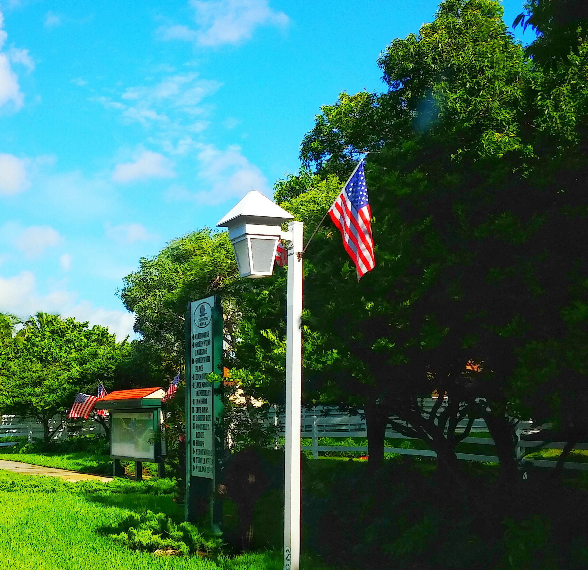 The entrance sign to Country Walk Florida with an American flag.
