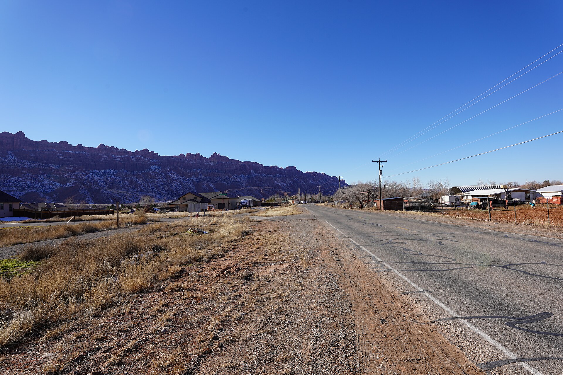 Road through Spanish Valley, Utah beneath red-rock cliffs