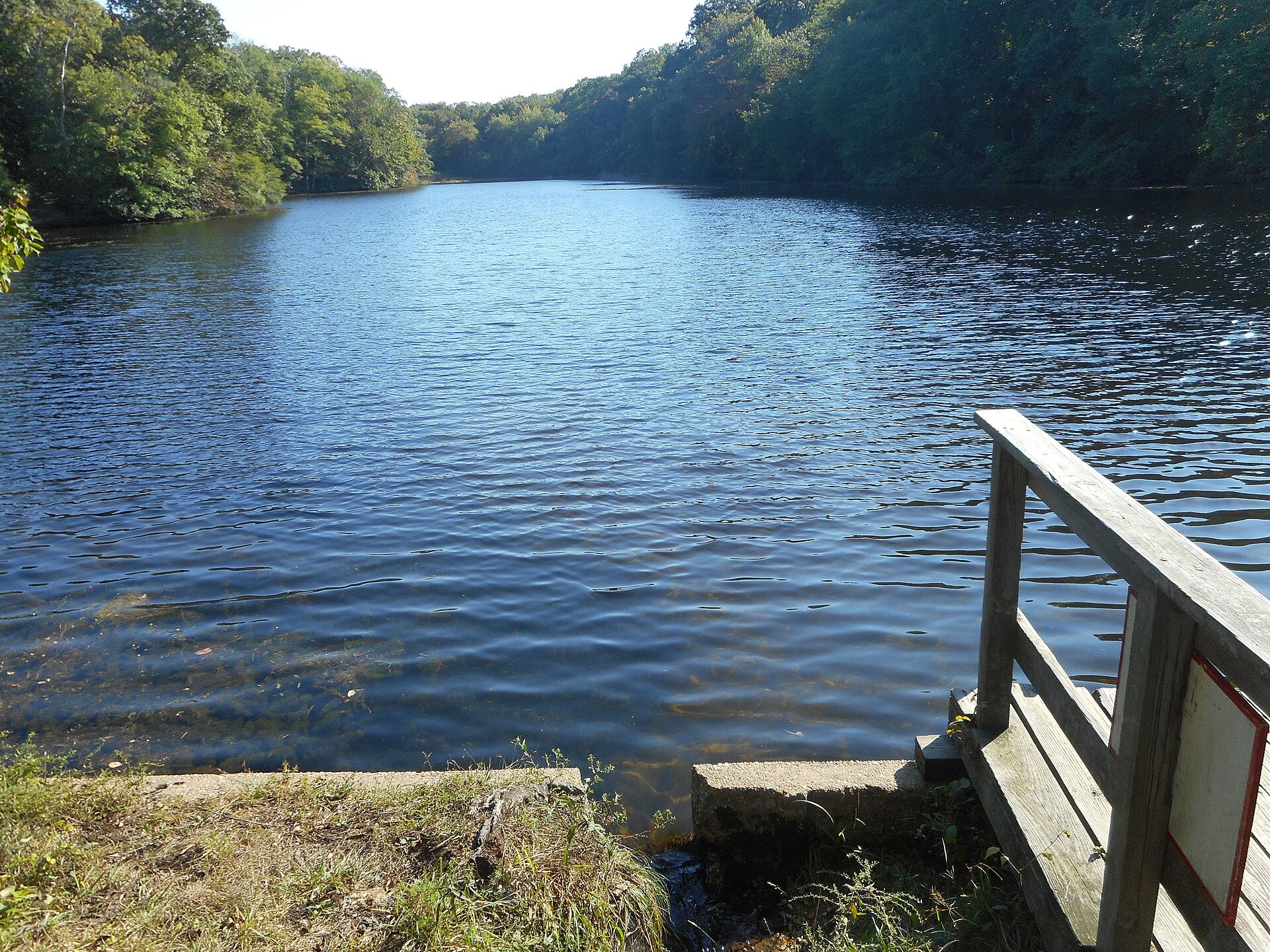 Calm pond surrounded by trees at Trout Pond Park in Noyack