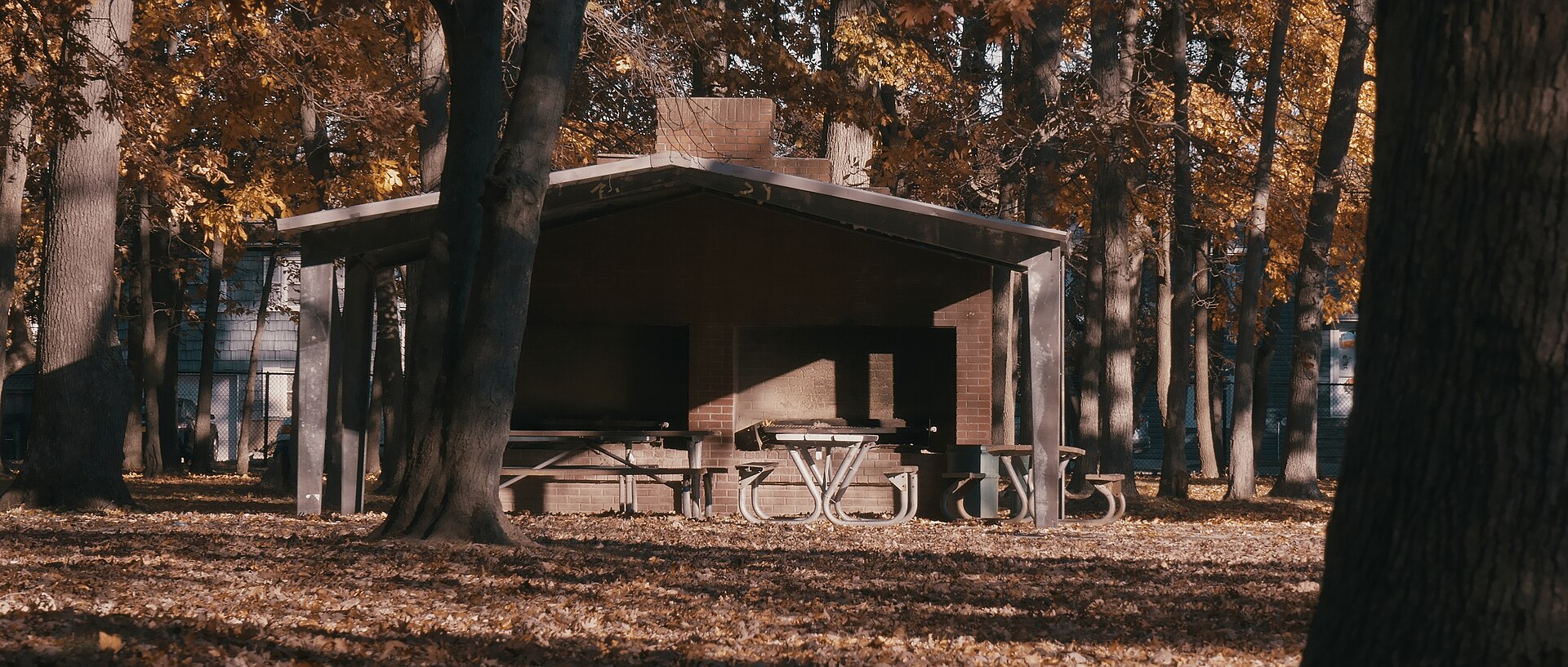 A brick picnic pavilion among autumn trees at Marjorie Post Park in East Massapequa, New York