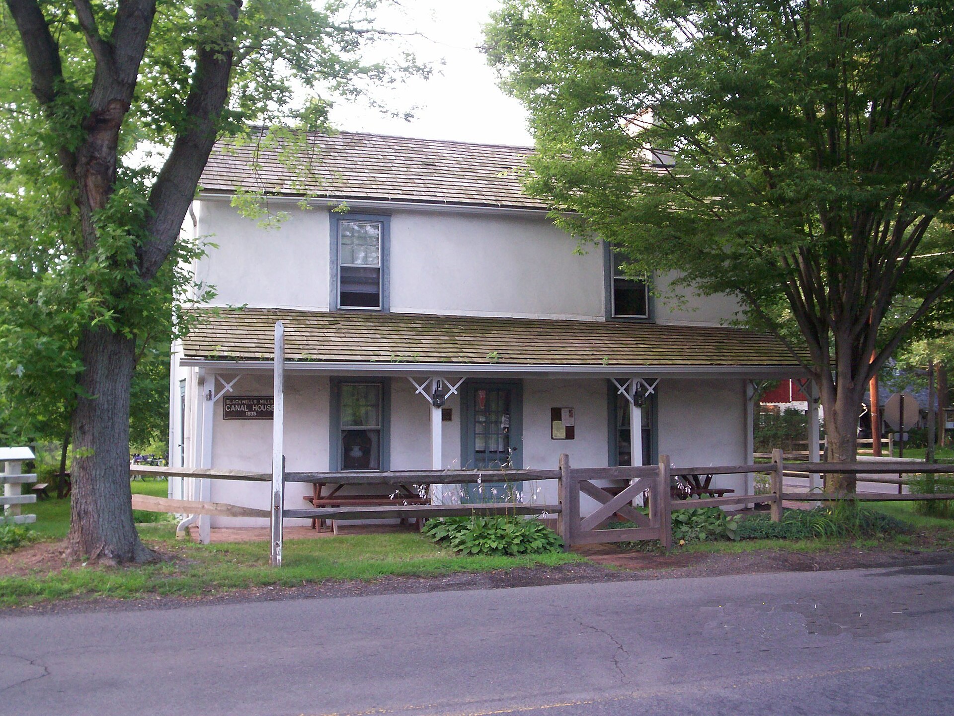 A historic white canal house with a porch in Blackwells Mills, New Jersey.