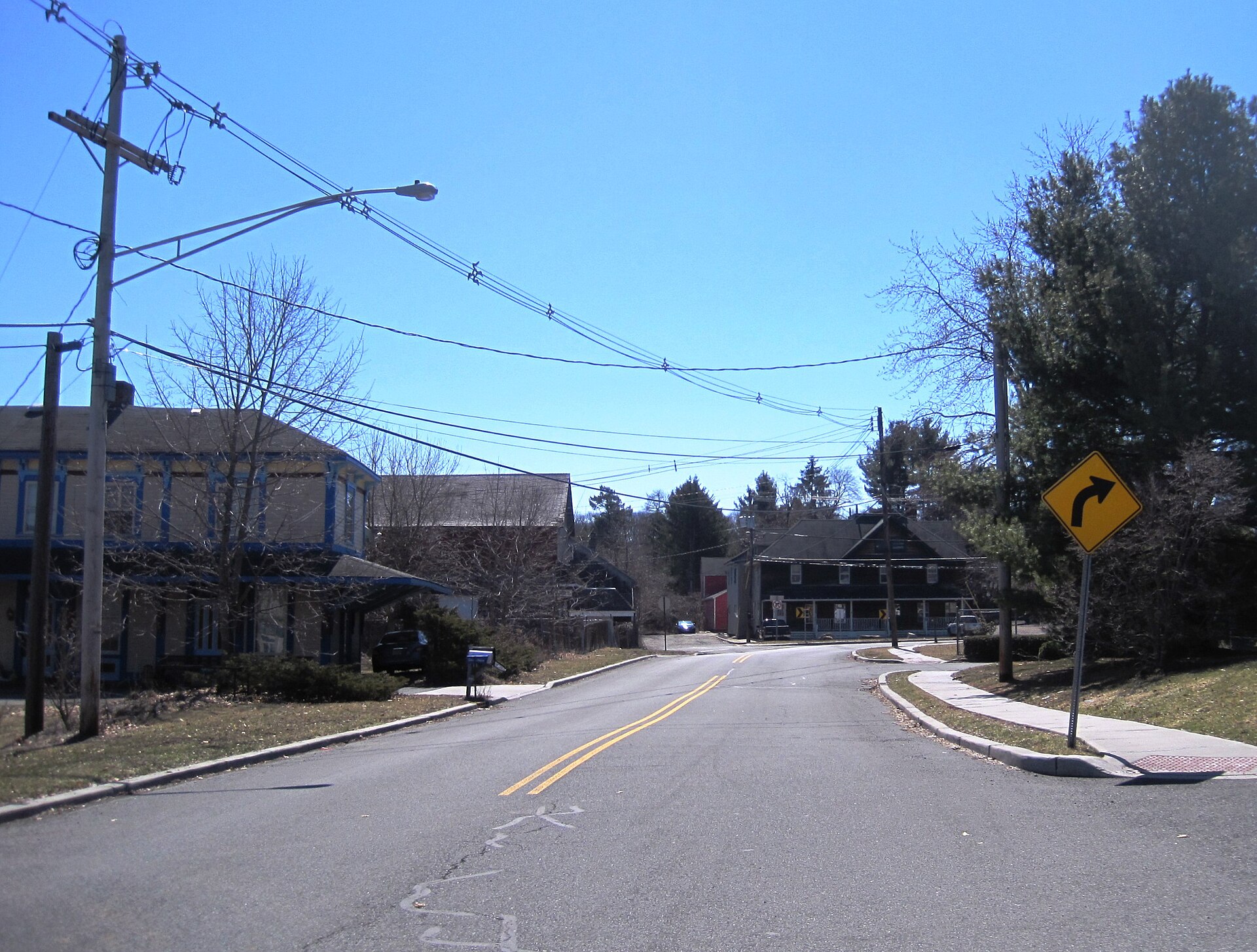 A street with a railroad crossing sign in Neshanic Station New Jersey.