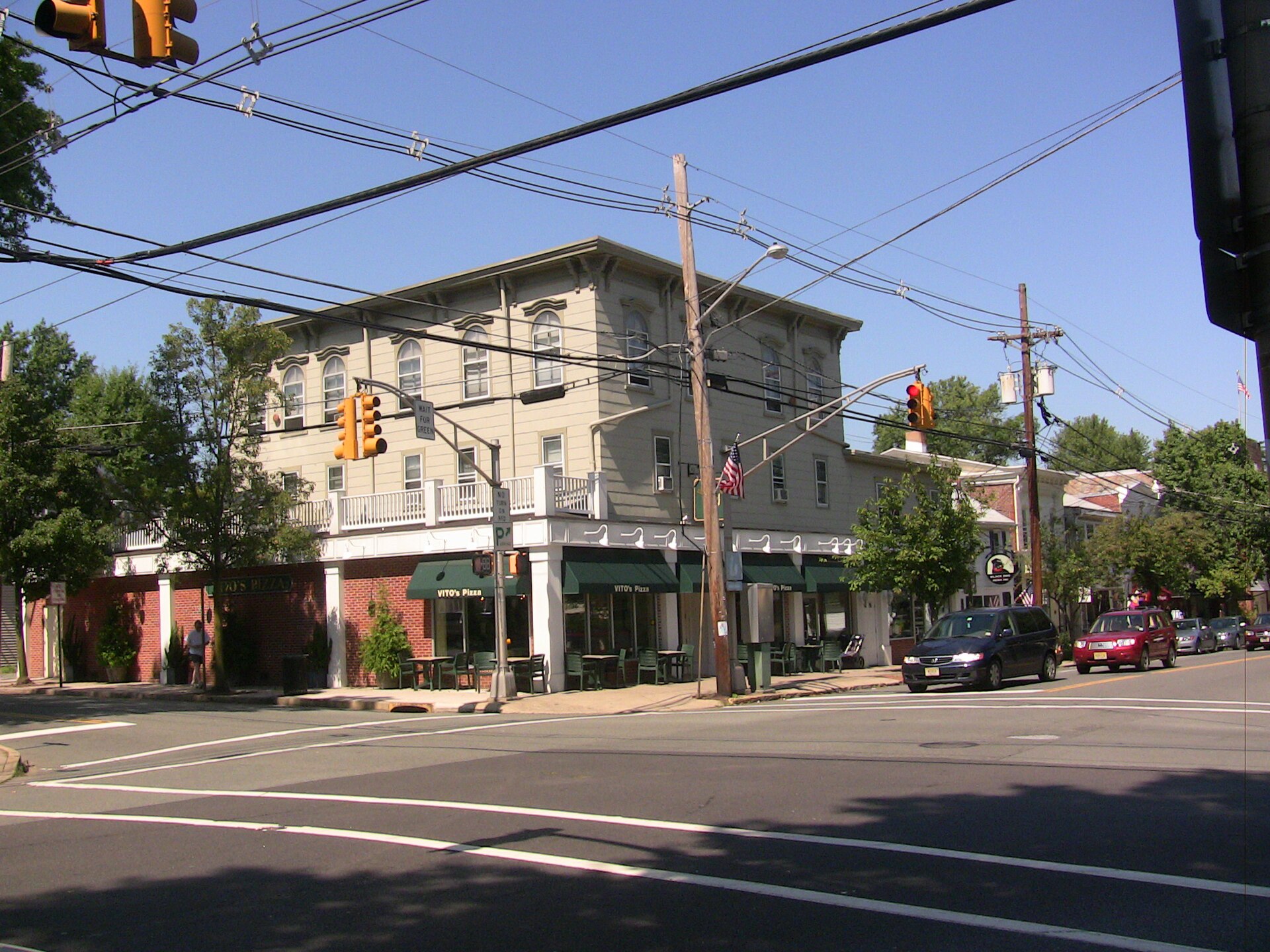 A historic brick commercial building on a street corner with traffic lights.