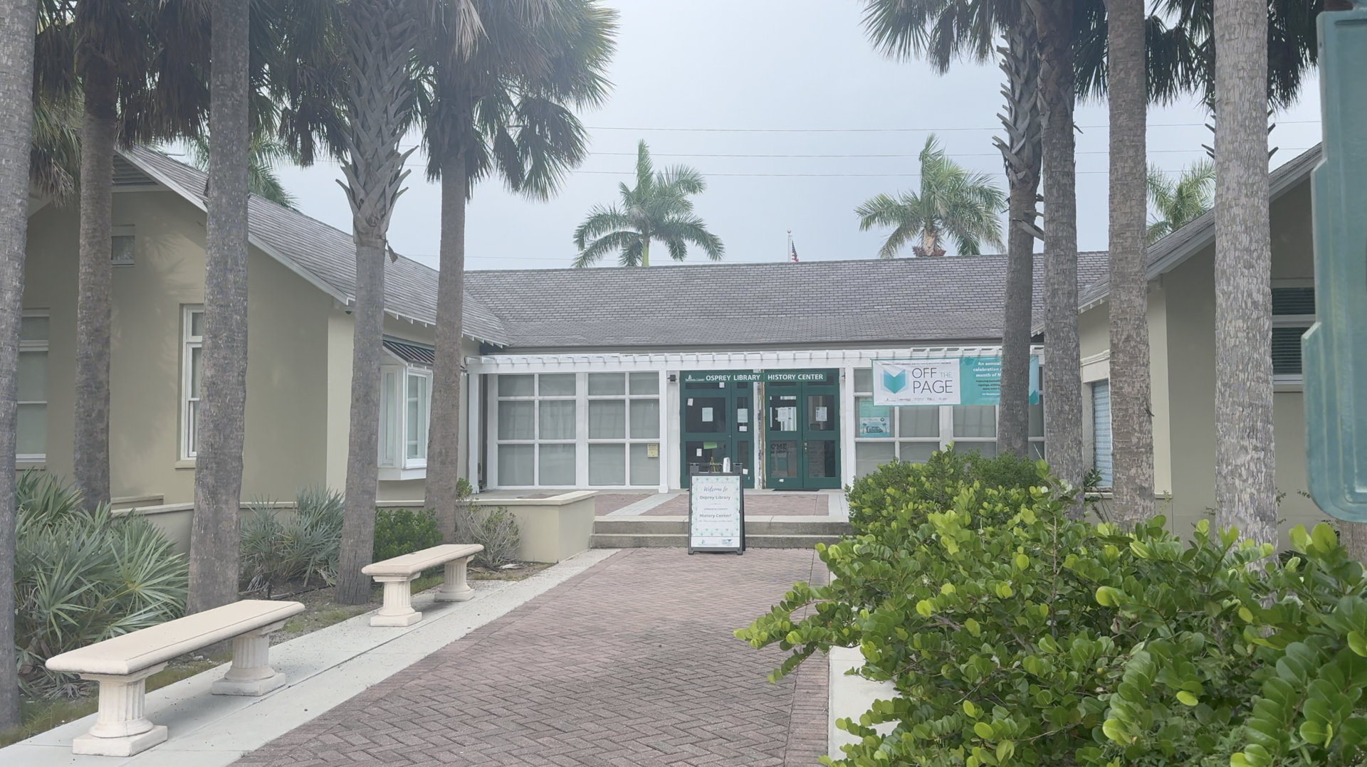 The front of the Osprey Library building with palm trees in Osprey, Florida.