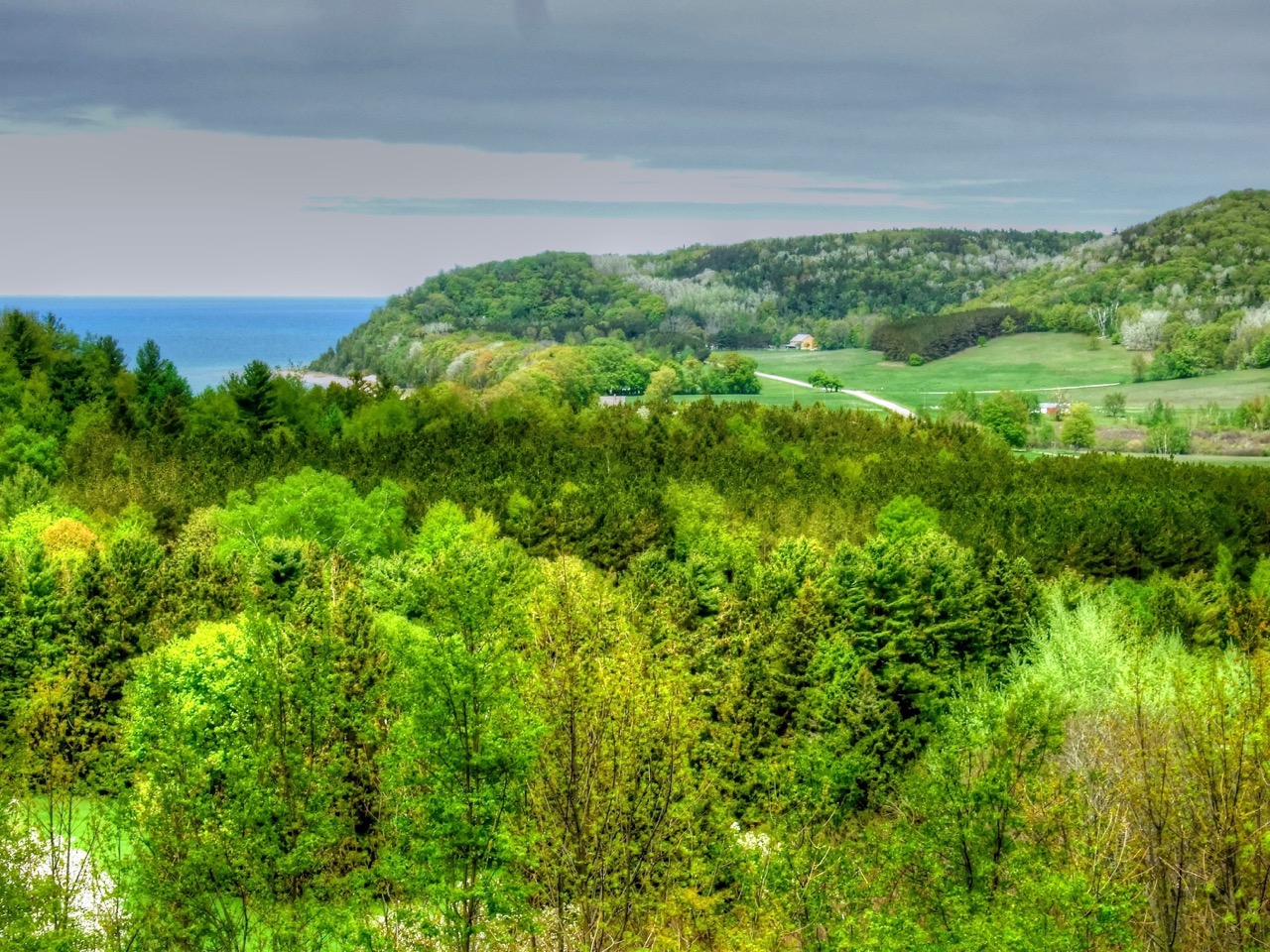 Rolling green hills and a distant lake seen from Bayview Lookout.