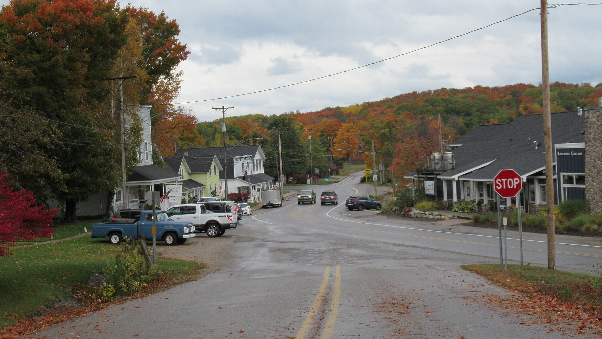 M-22 street view in Omena, Michigan, with shops and fall color on the surrounding hills