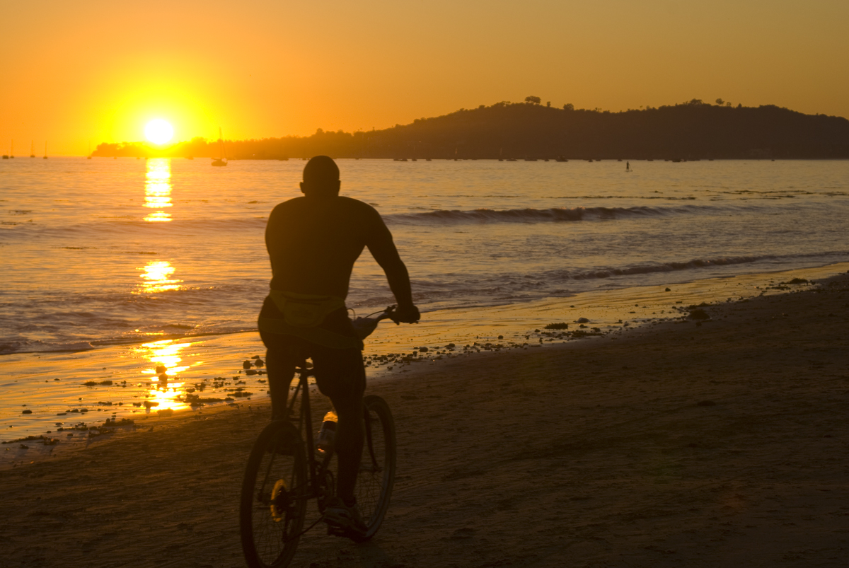 Cyclist on the sand at sunset on a Montecito-area beach