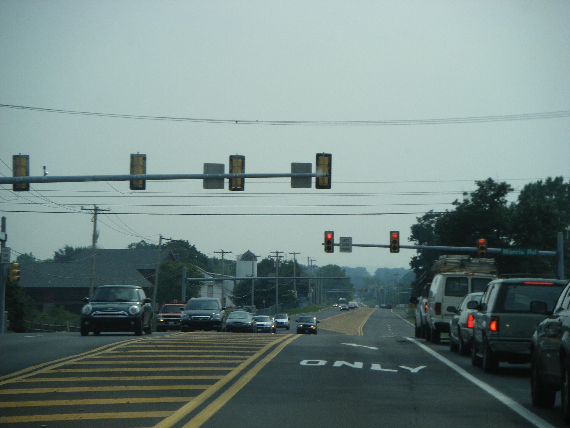 A suburban arterial intersection with traffic lights and cars.