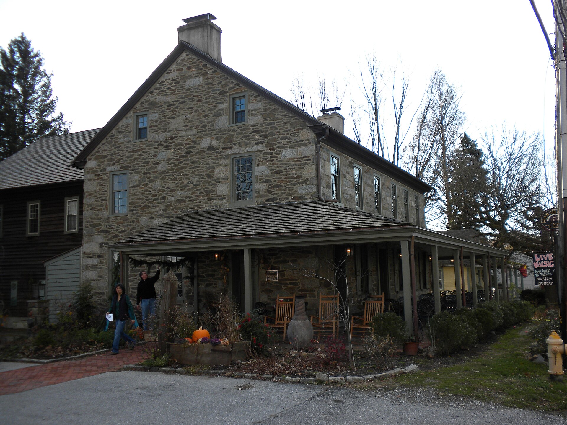 A stone inn building with a covered porch.