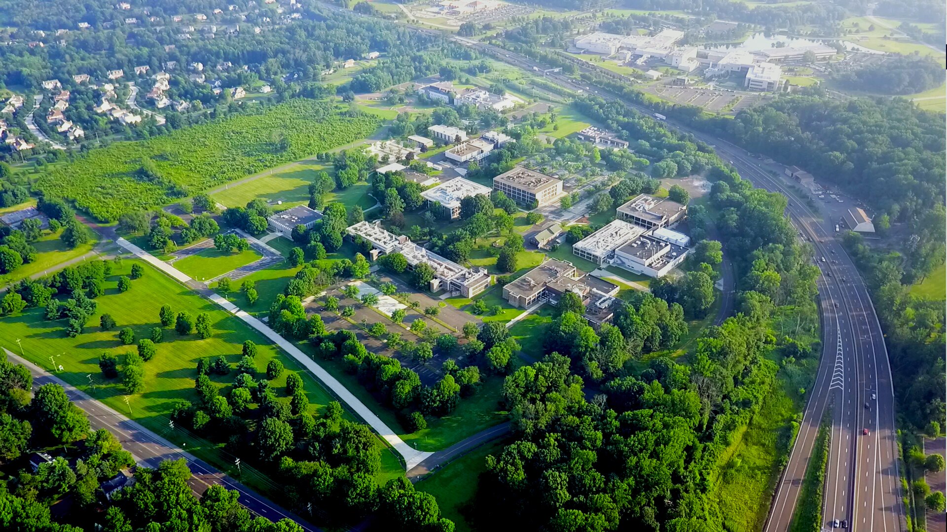 An aerial view of the Spring House Innovation Park campus with green lawns and office buildings.