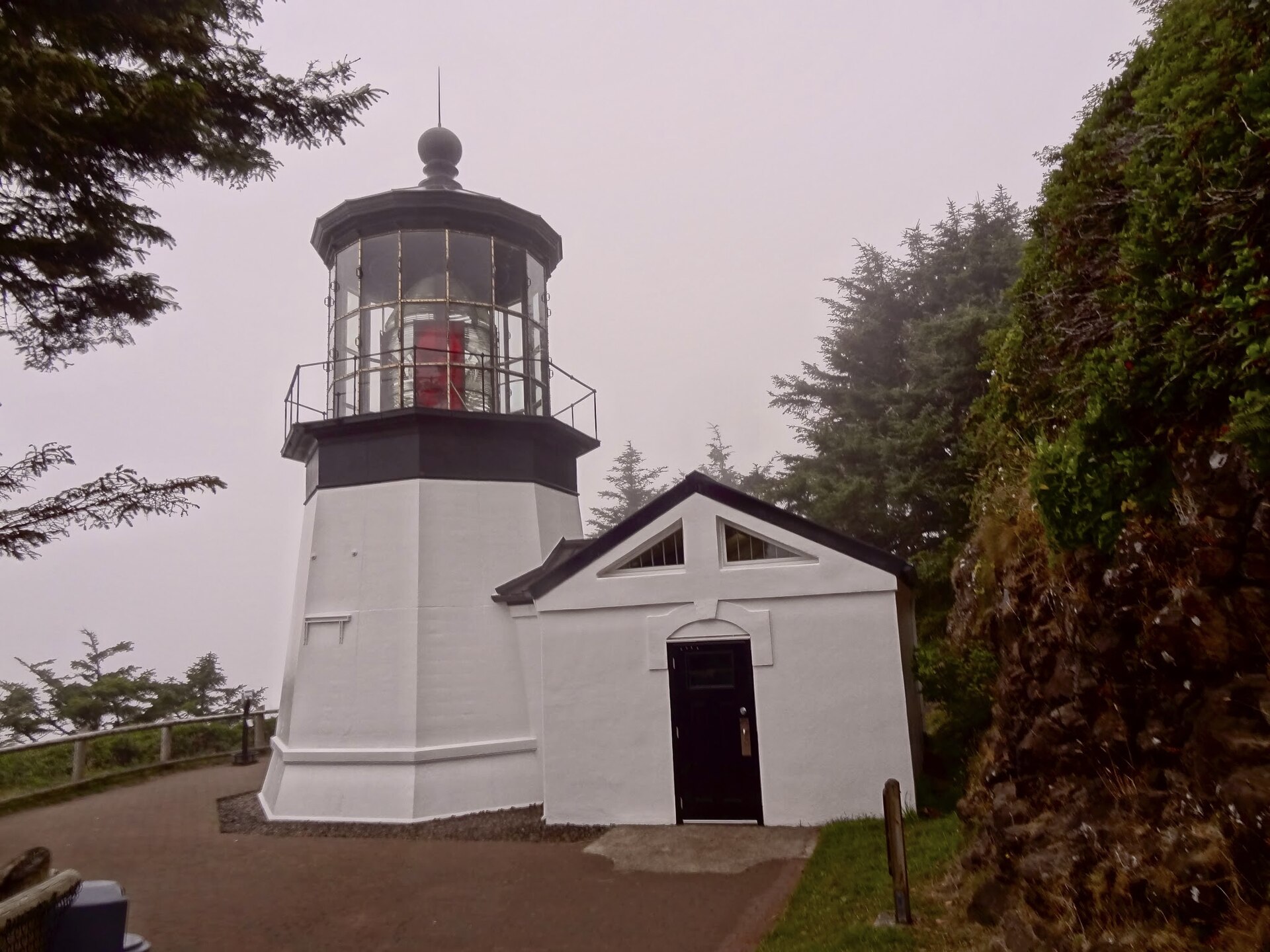 The white Cape Meares Lighthouse emerging from coastal fog