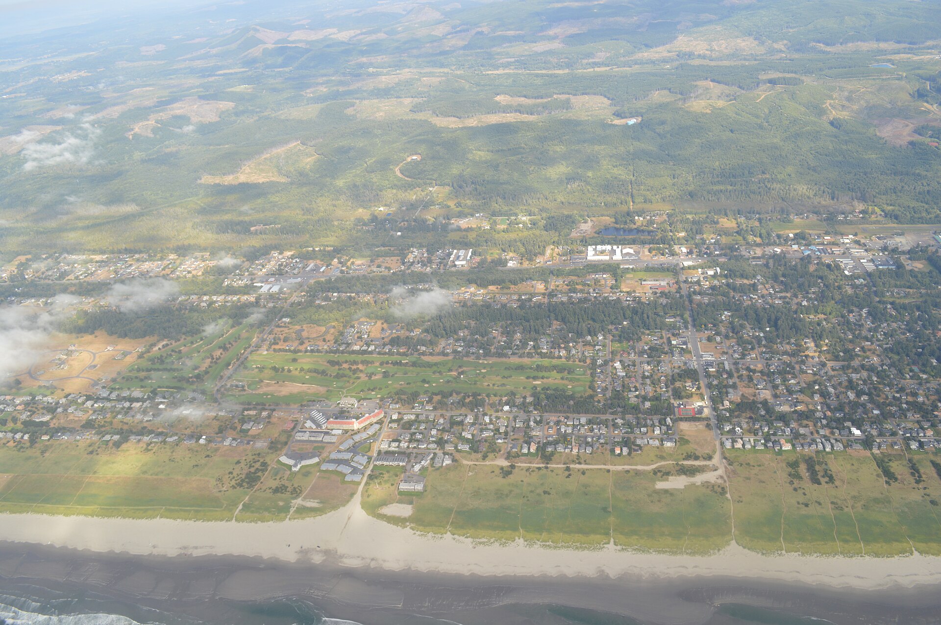Aerial view of Gearhart, Oregon, with the beach, golf course, and Coast Range beyond