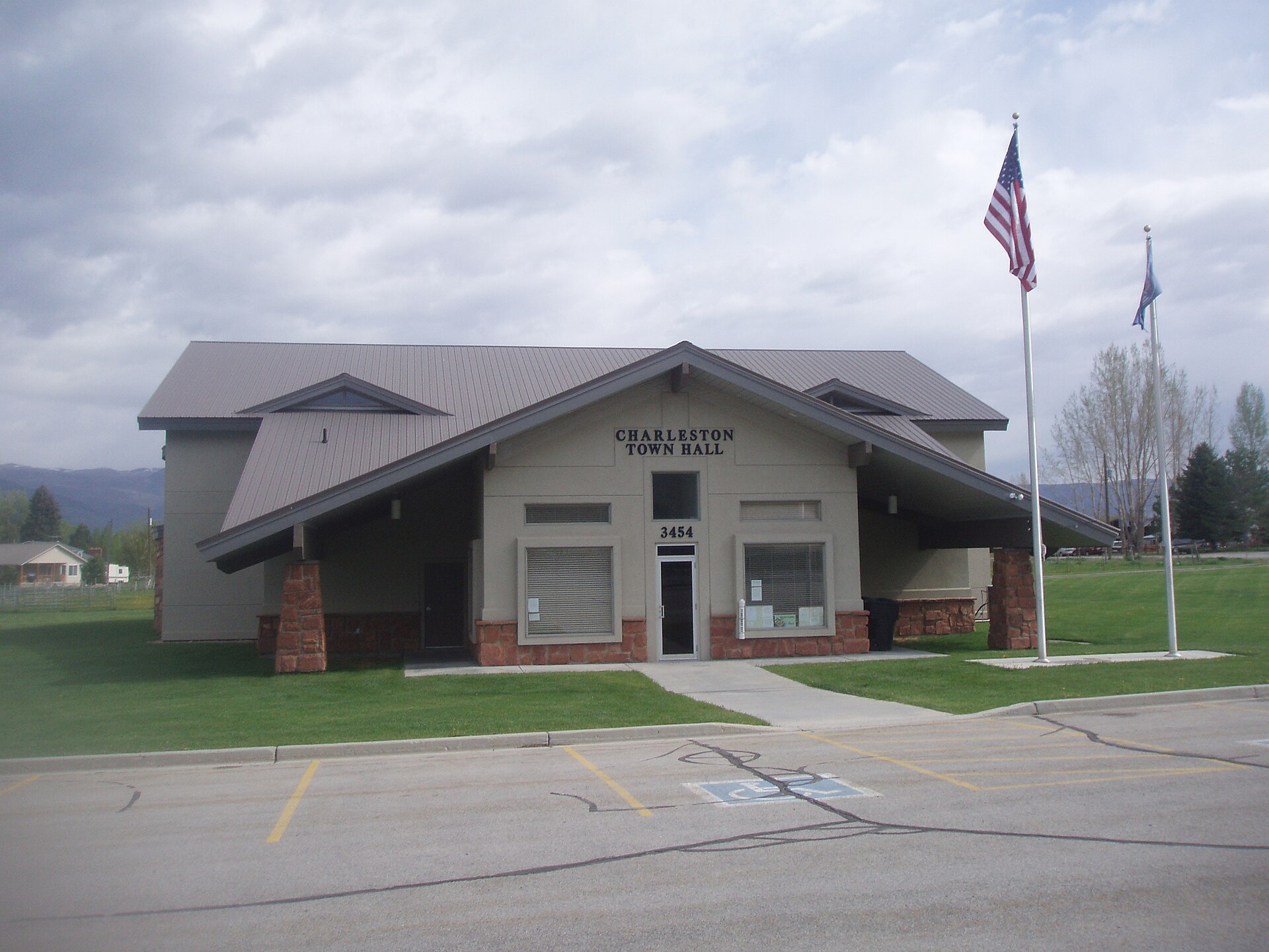 A modern town hall building with a flagpole and parking lot.