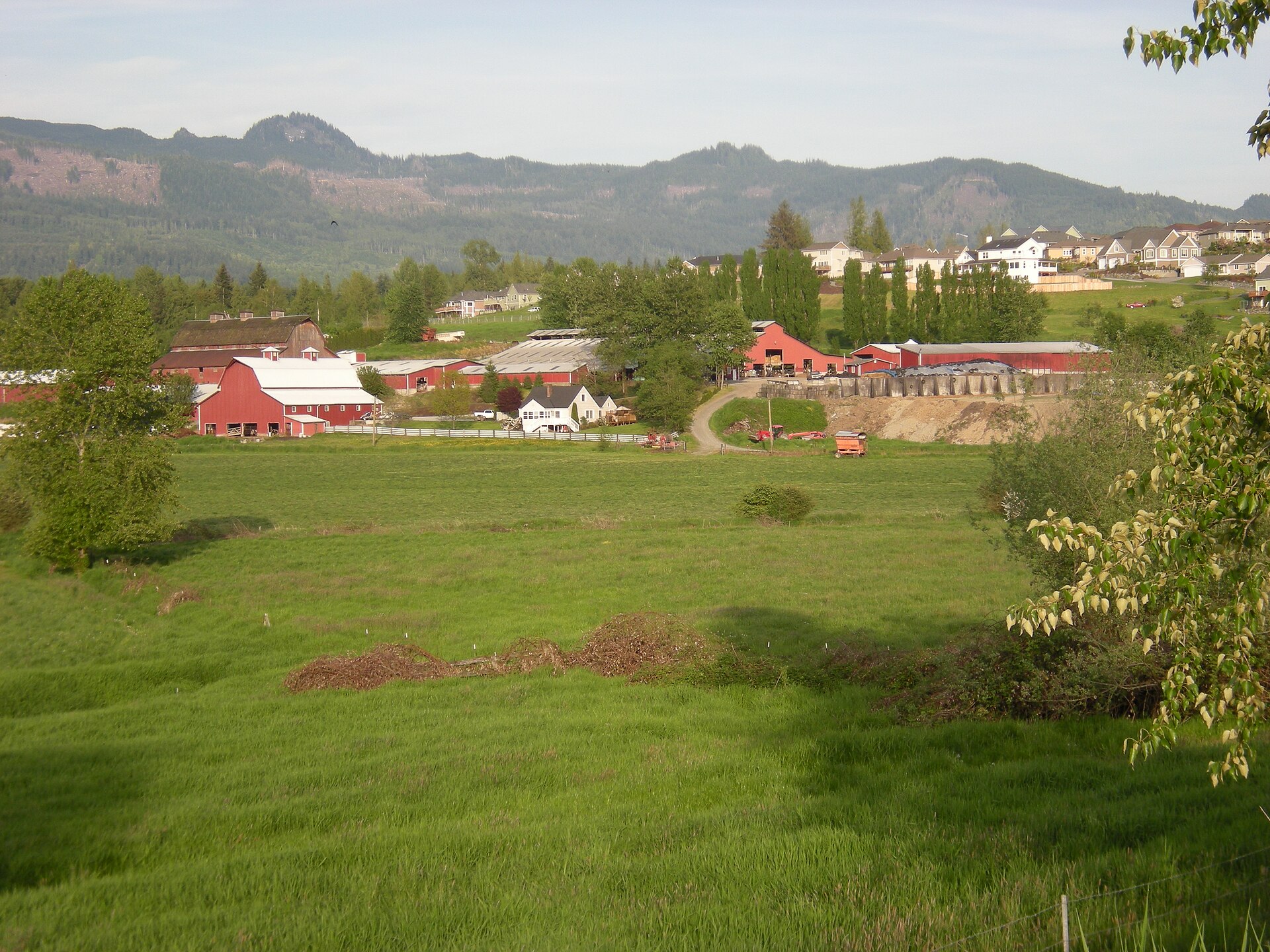 A farm in the foreground with a new suburban subdivision behind it in Big Lake Washington.