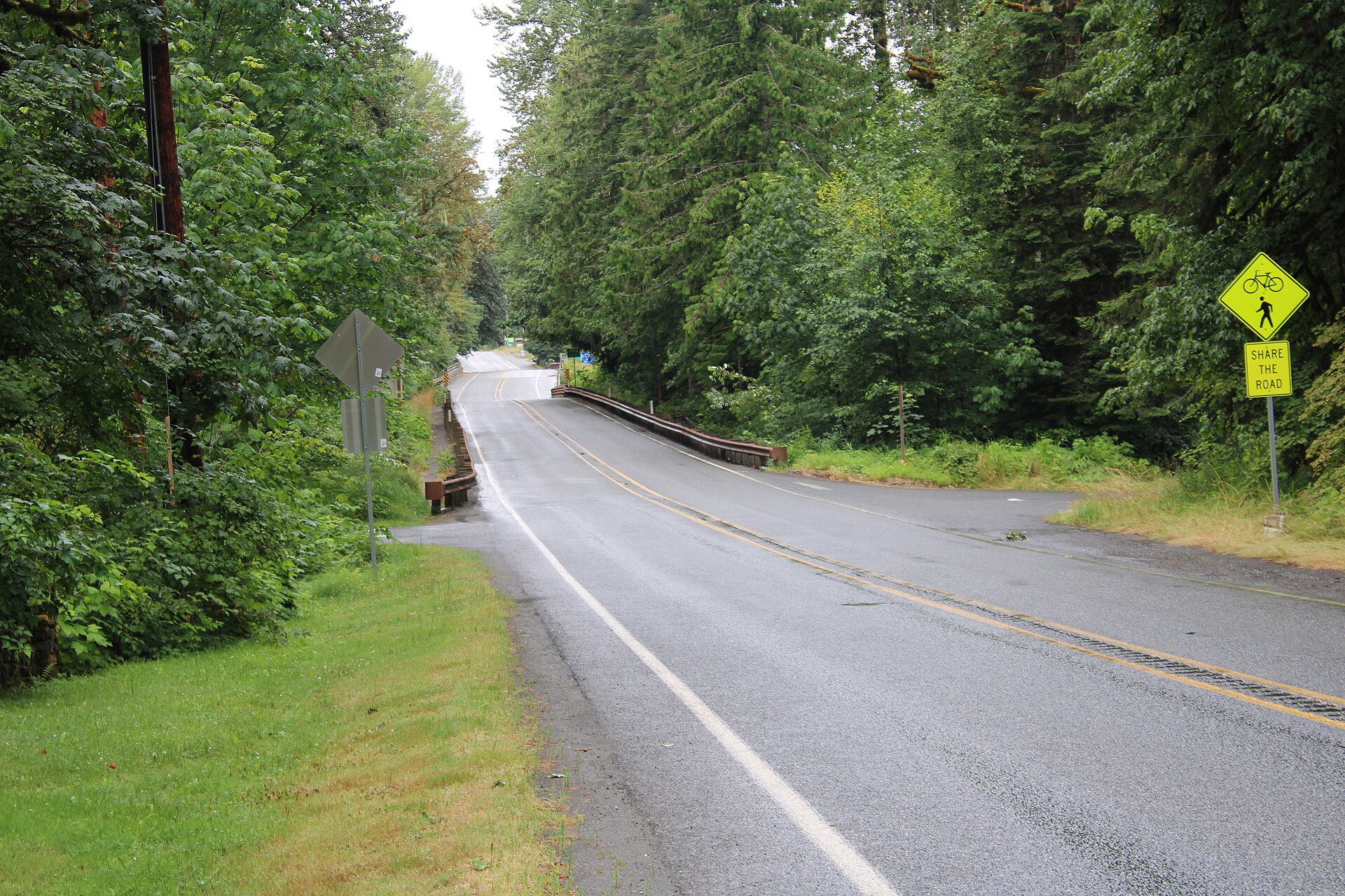A paved road through evergreen forest approaching Glacier, Washington, on State Route 542.