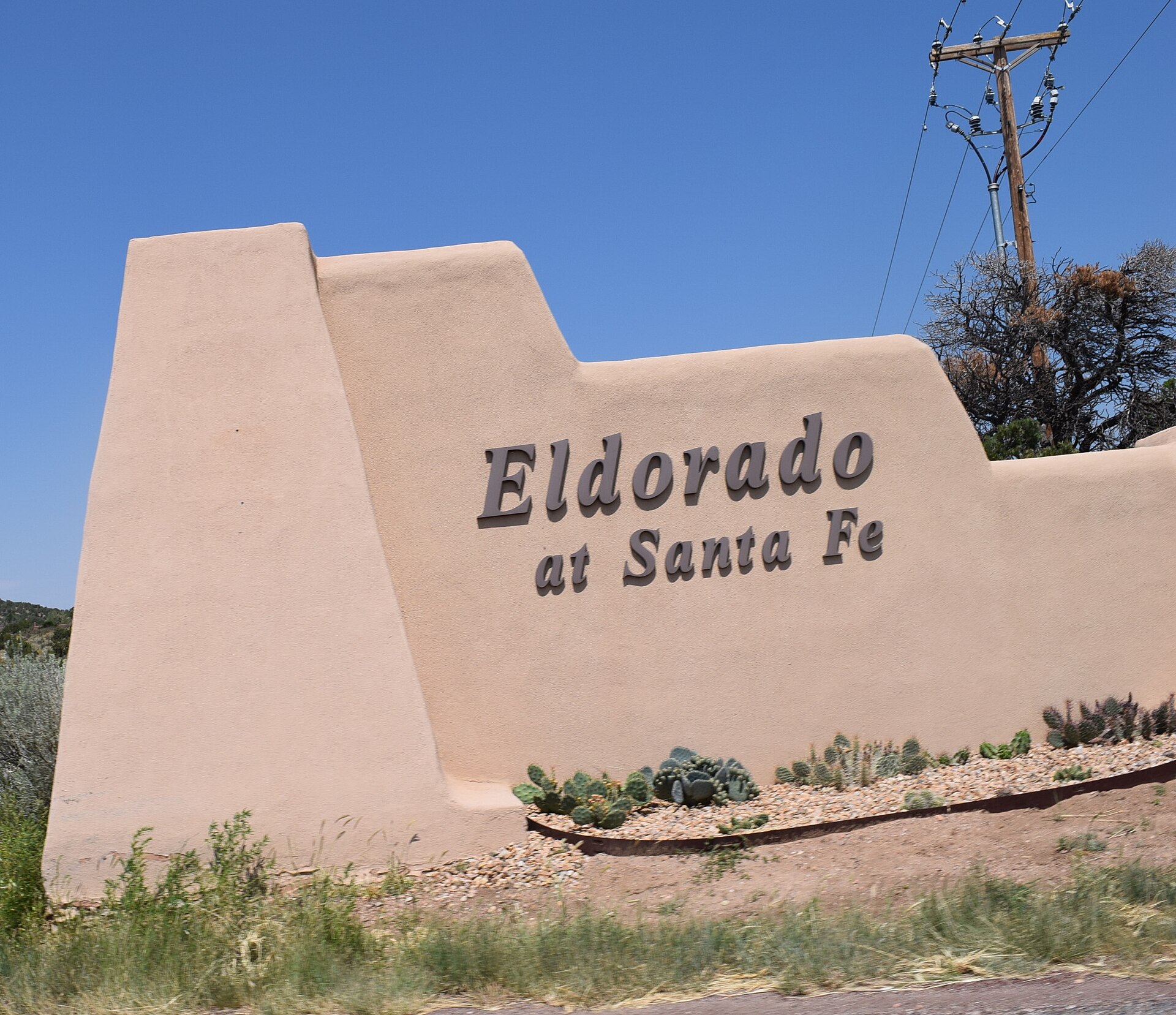 An adobe-style entrance sign reading Eldorado at Santa Fe in Eldorado, New Mexico.