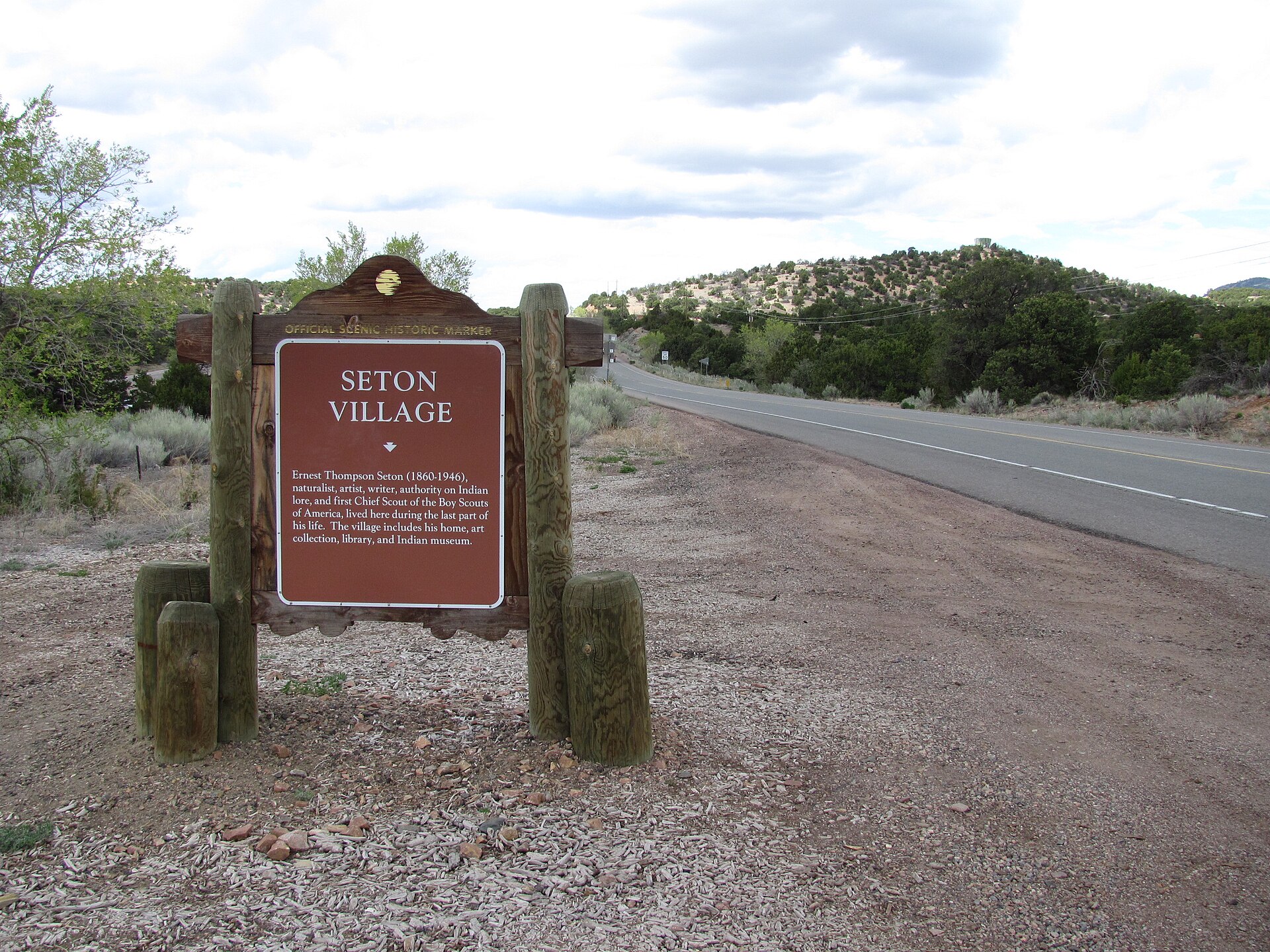 A wooden sign marking Seton Village New Mexico along the highway.