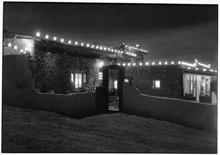 An adobe building at Seton Village New Mexico illuminated at night.