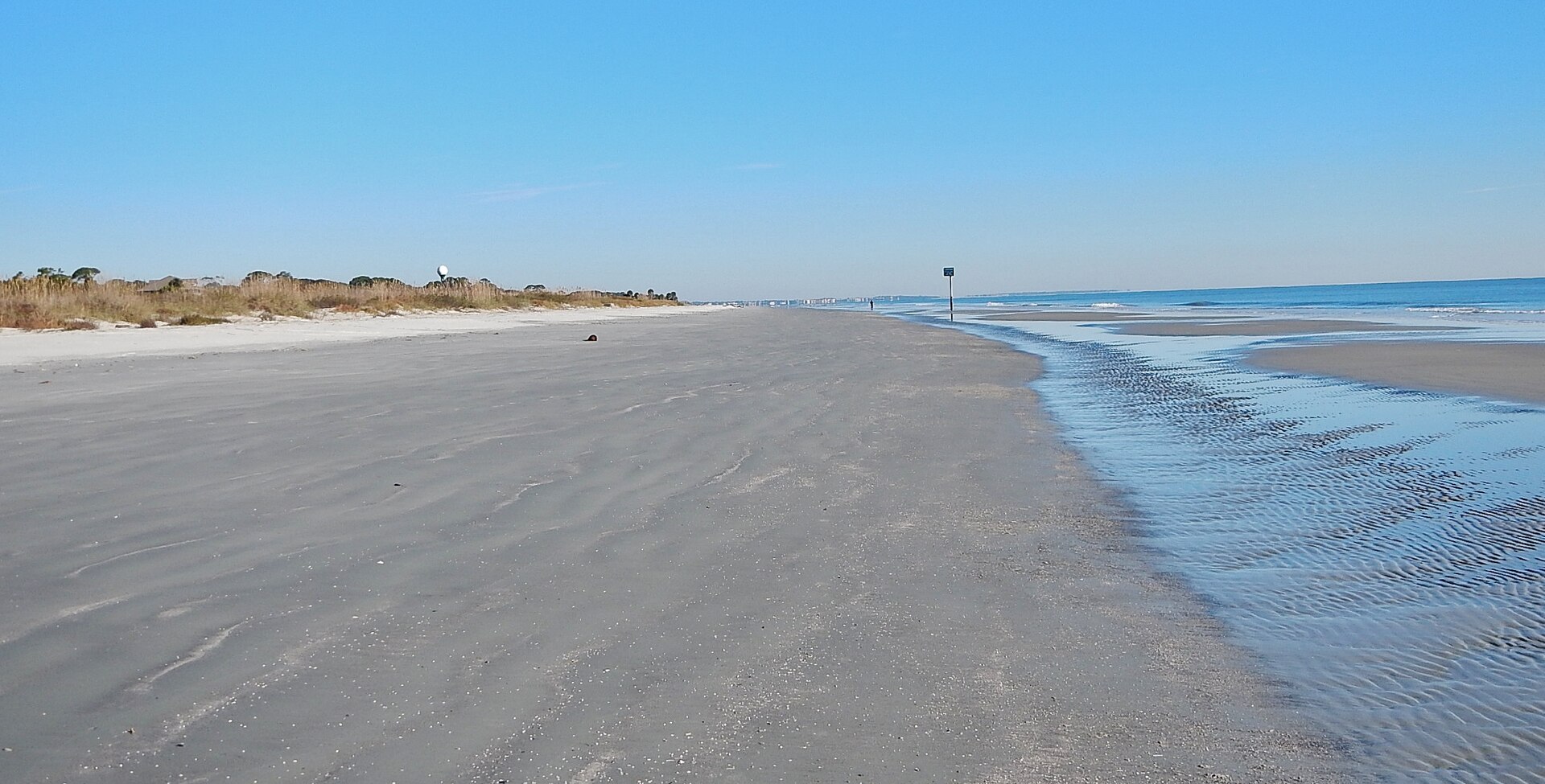 A wide sandy beach with gentle waves on Jekyll Island Georgia.