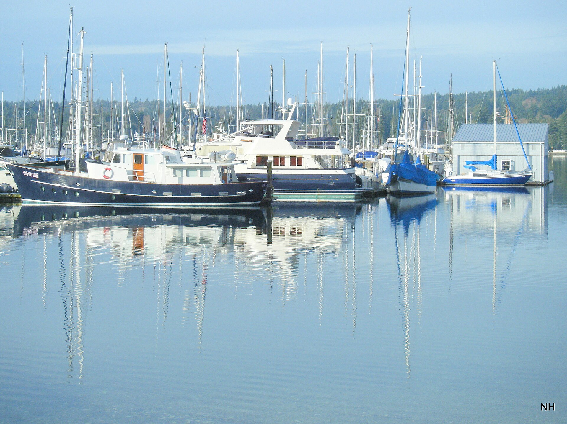 Boats docked at the marina in Poulsbo Washington with calm water reflections.