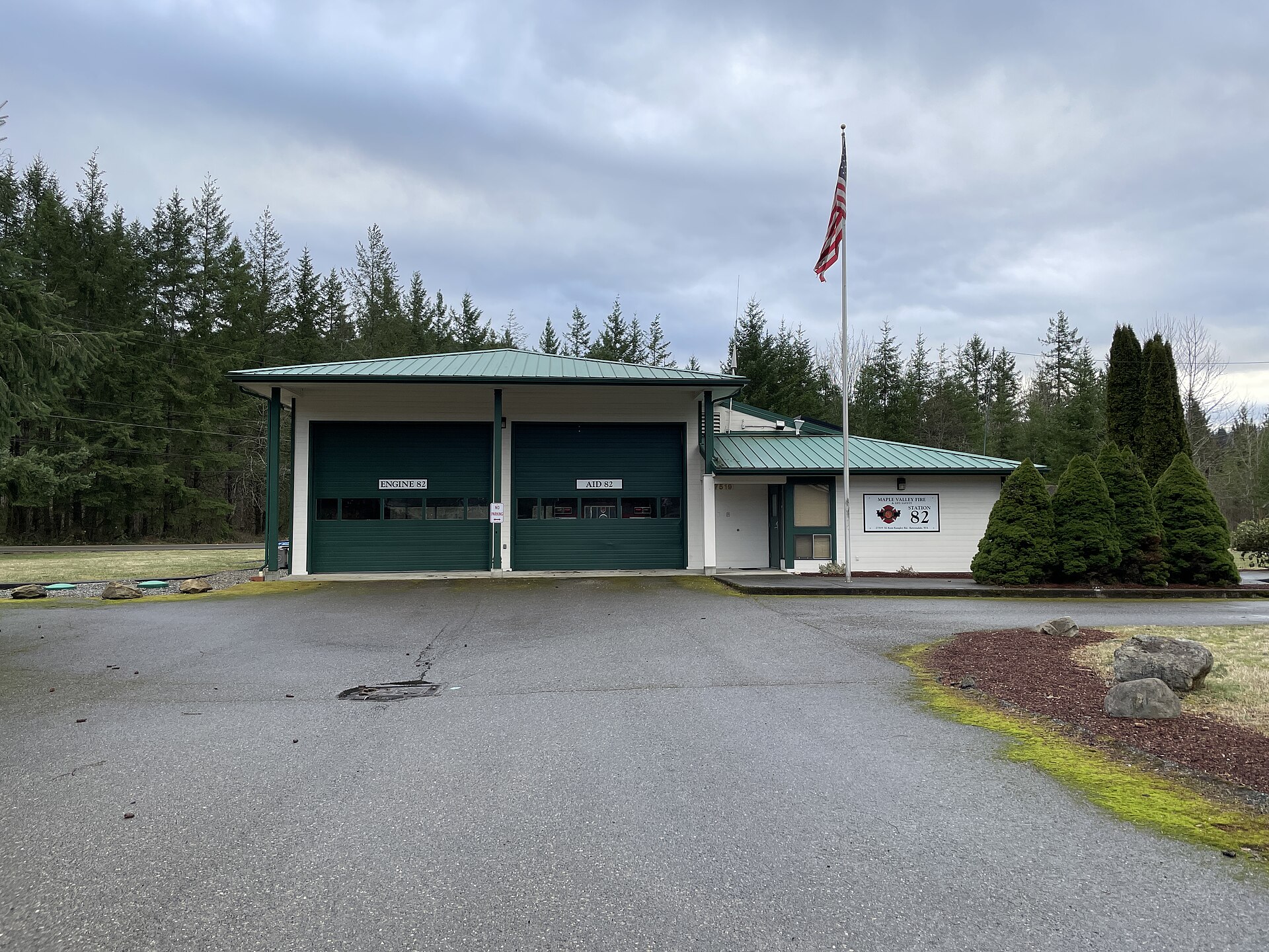 Ravensdale's fire station, a low green-roofed building with an American flag out front.