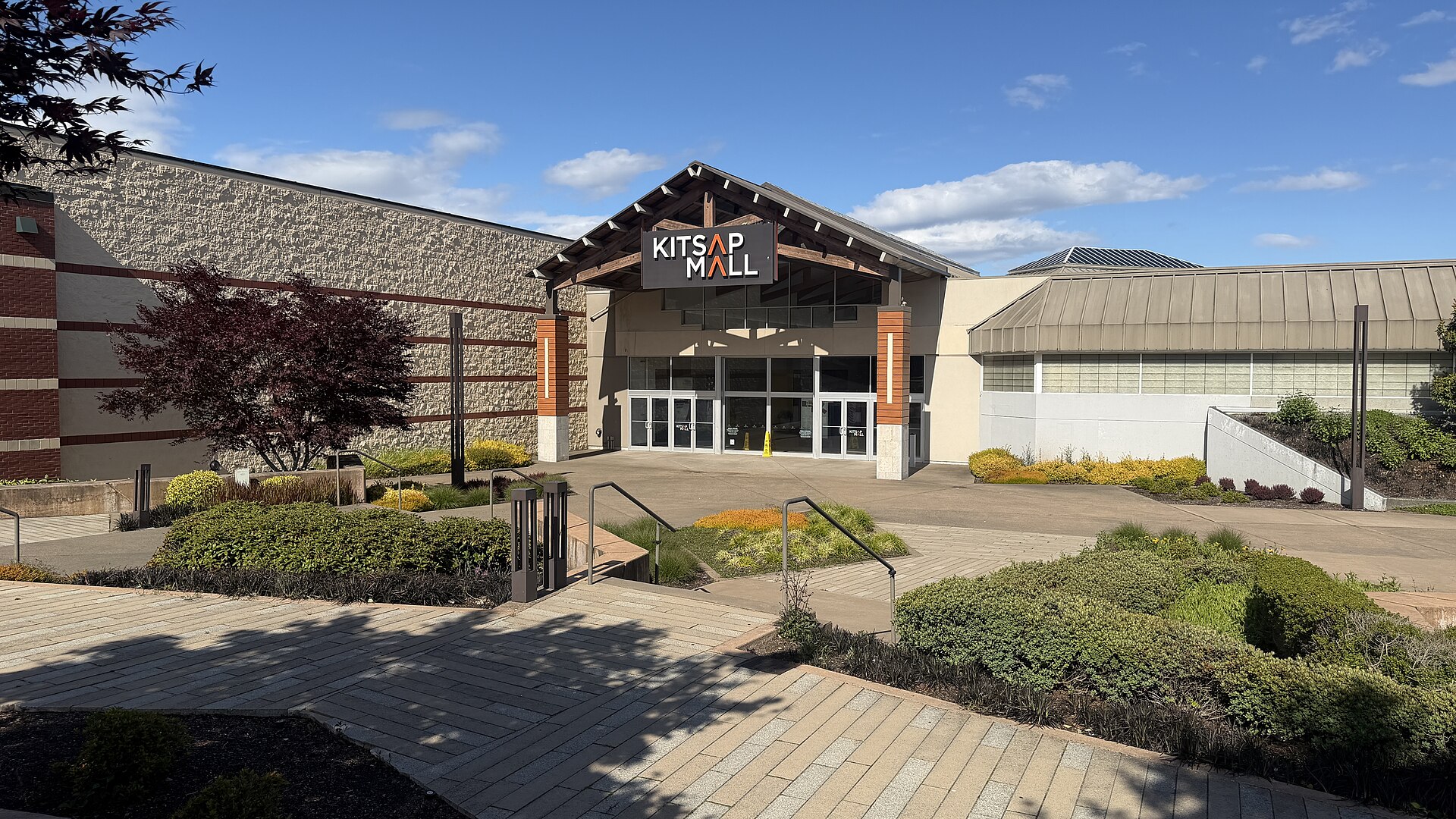 The landscaped entrance of the Kitsap Mall on a sunny day.