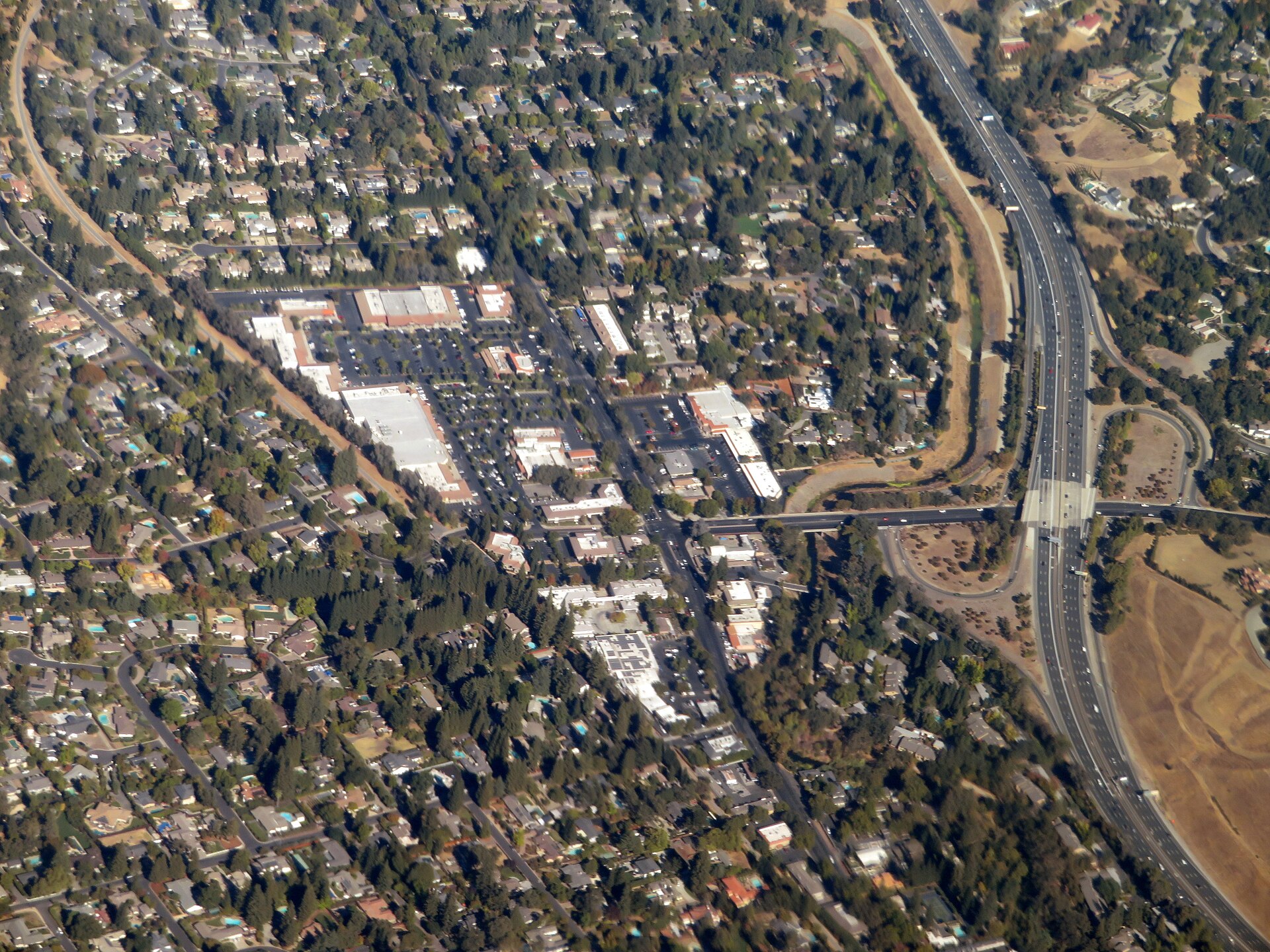 An aerial view of Alamo's tree-lined neighborhoods with Interstate 680 running along the right.
