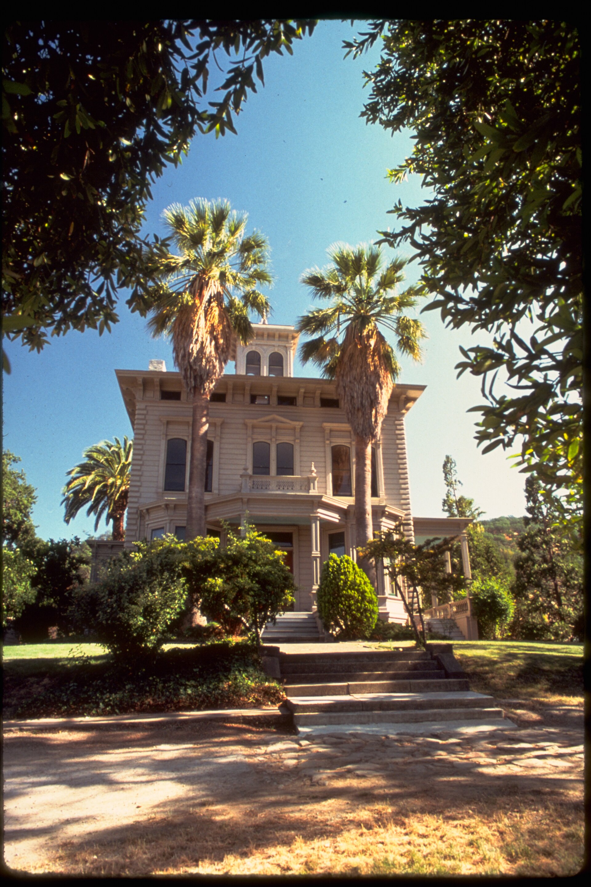 A historic Victorian mansion with palm trees in Alhambra Valley.