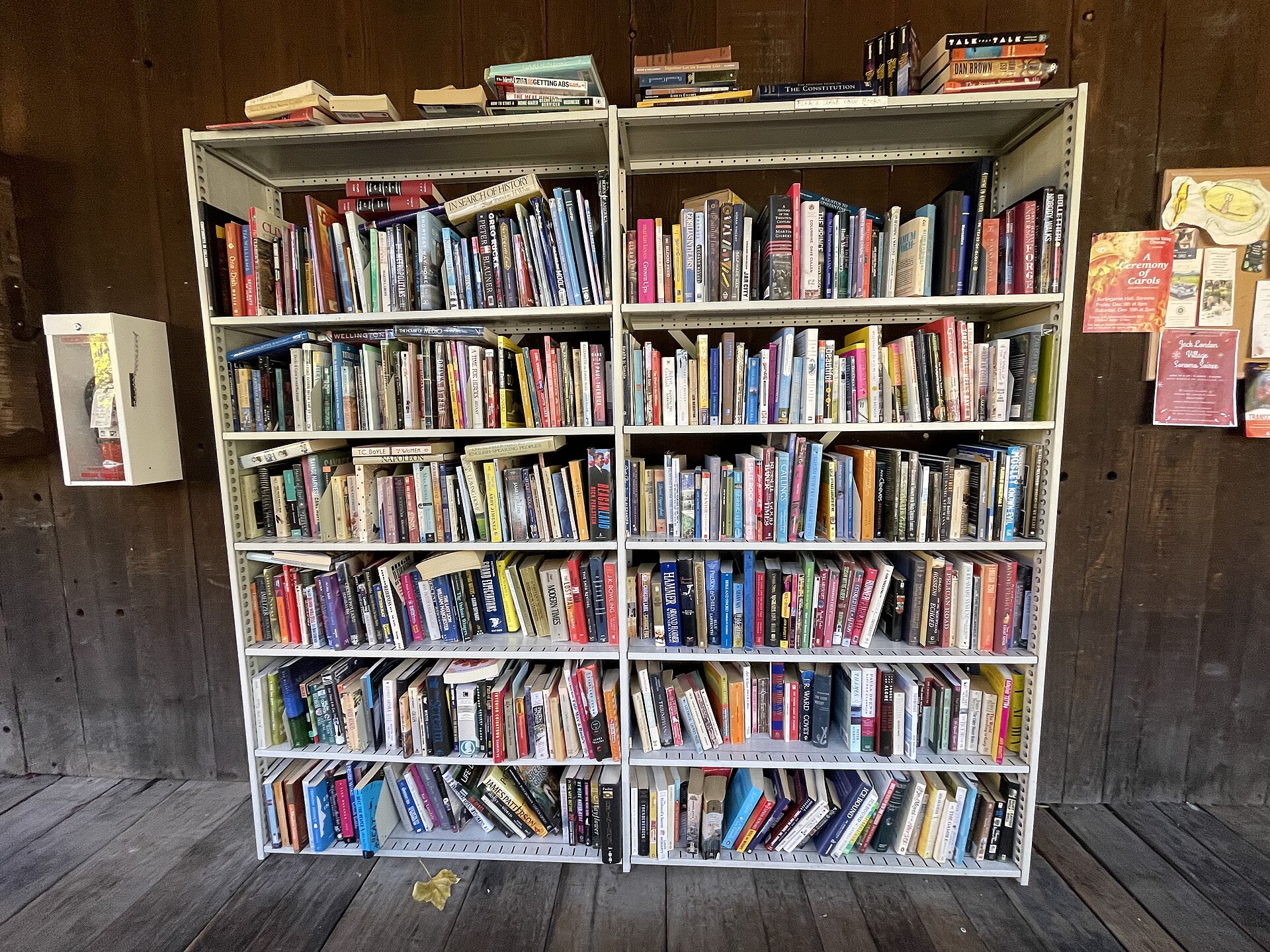 A little free library bookshelf stocked with books on a wooden porch in Glen Ellen.